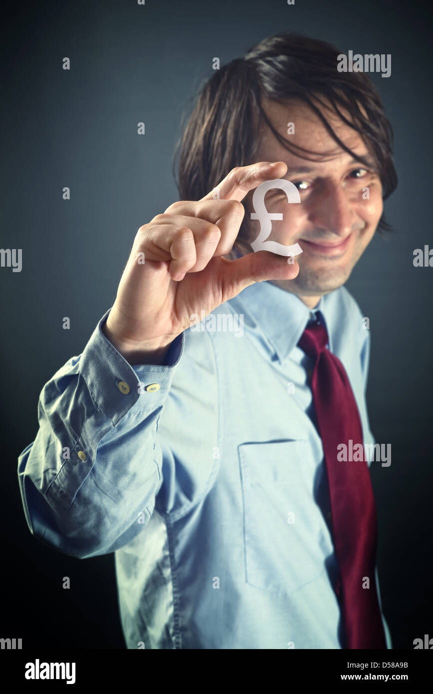 Businessman holding small pound currency symbol in hands. Stock Photo