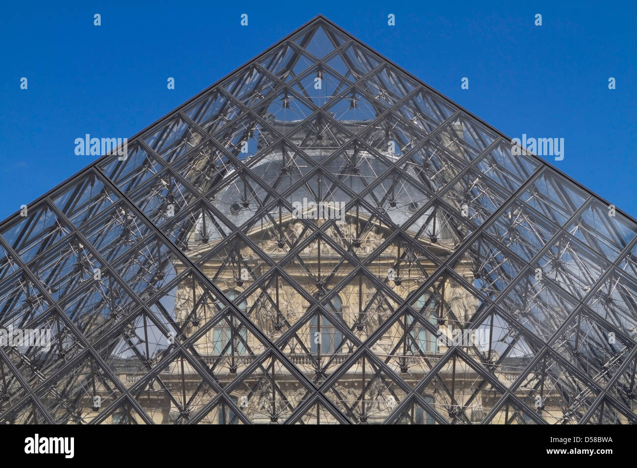 The Louvre museum seen through the glass pyramid in Paris, France Stock Photo