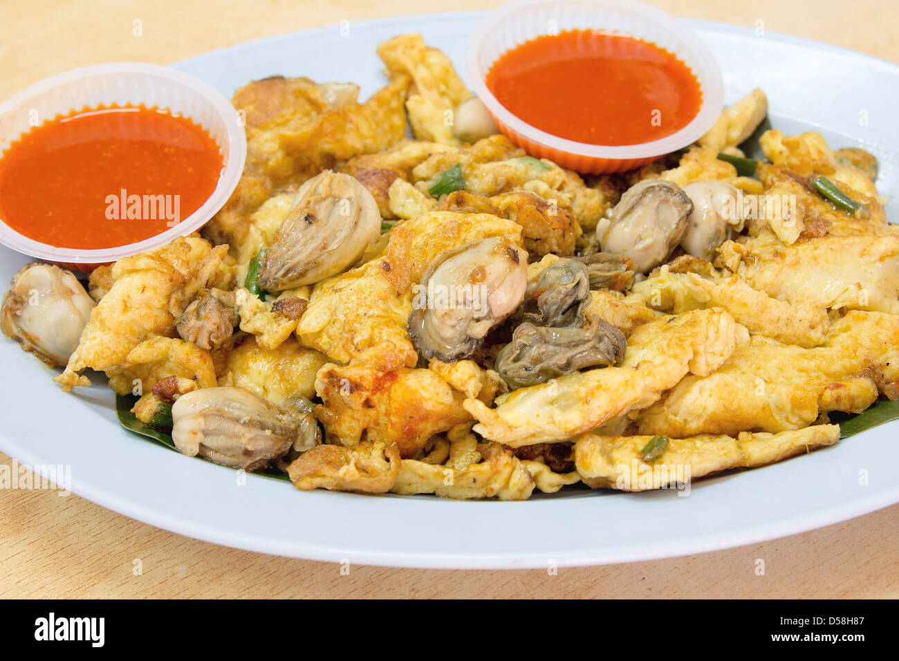 Southeasat Asian Fried Baby Oyster Omelette Oh Chien with Chili Sauce Closeup Stock Photo