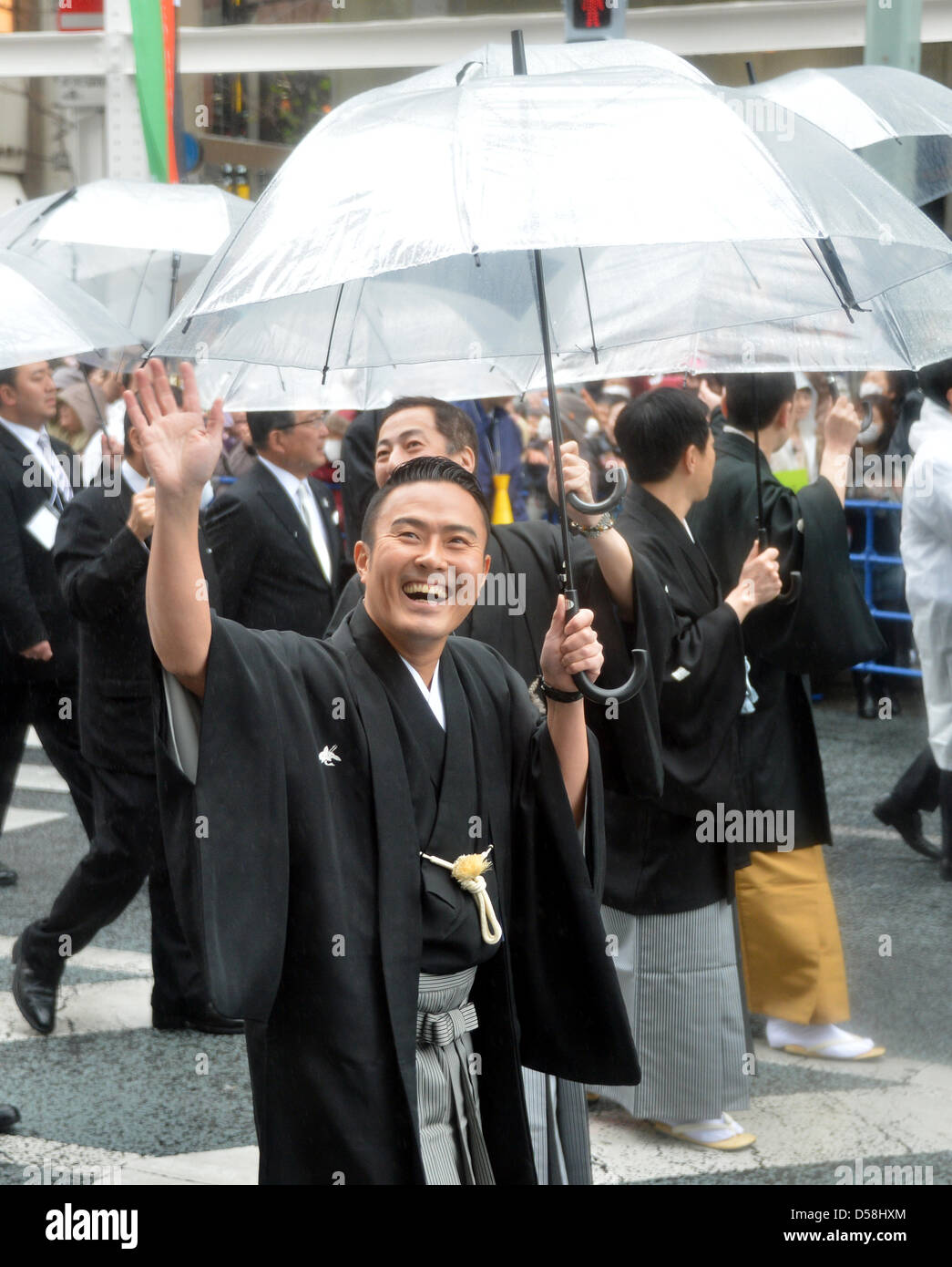 Tokyo, Japan. 27th March 2013. Ichikawa Ukon waves to fans as some 60 leading Kabuki actors parade in the rain through the main street of Tokyo's Ginza shopping district on Wednesday, March 27, 2013, in celebration of the grand opening of new Kabuki theater. After three years of renovation, the majestic theater for Japan's centuries-old performing arts of Kabuki will open its doors to the public with a three-month series of most sought-after plays. (Photo by Kaku Kurita/AFLO/Alamy Live News) FYJ-mis- Stock Photo