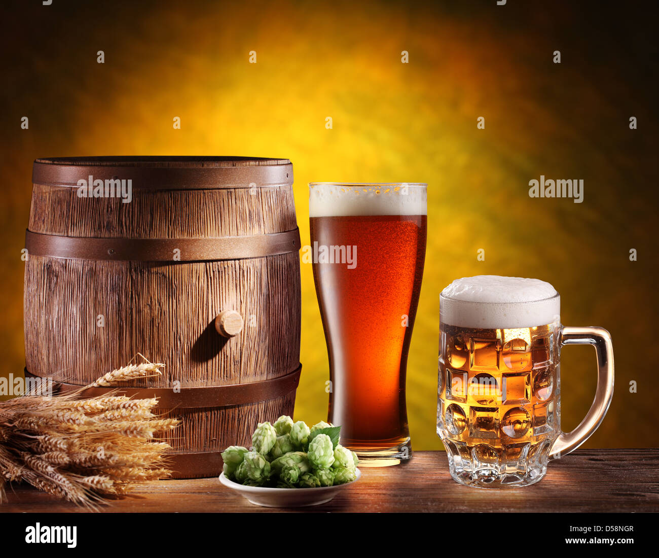 Beer glasses with a wooden barrel. Background - dark yellow gradient. Stock Photo