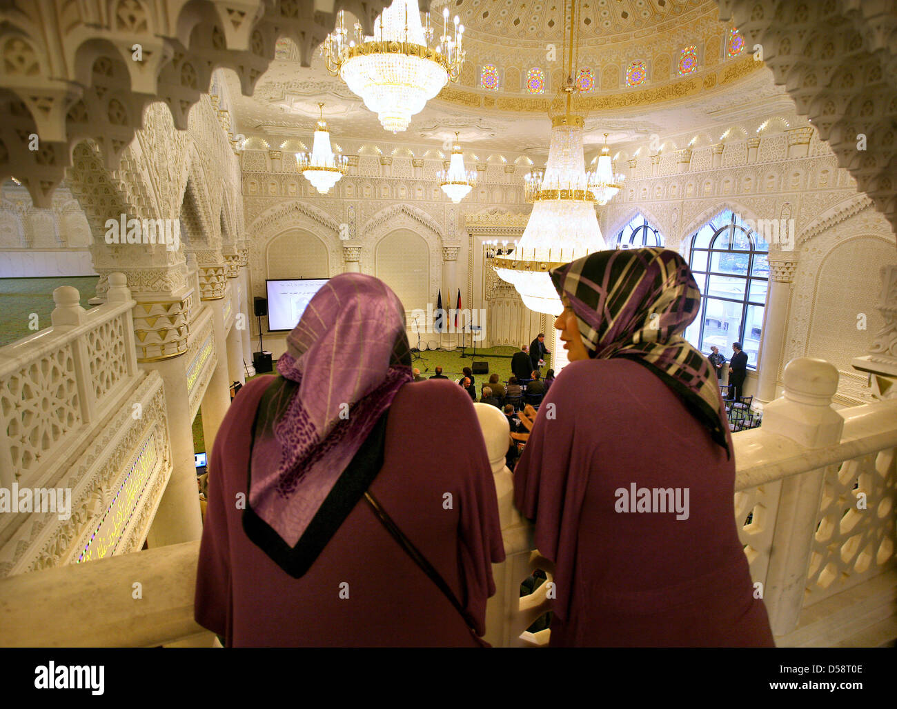 Two Turkish nursery nurses observe the opening ceremony of the new Omar-Ibn-Al-Khattar mosque in Berlin, Germany, 21 May 2010. The women work at a day-care centre which is situated in the newly built Maschari Center as are the mosque and business and seminar rooms. The exuberantly decorated mosque accomodates 1000 believers. According to public authoritites, 300 000 Muslims live in Stock Photo
