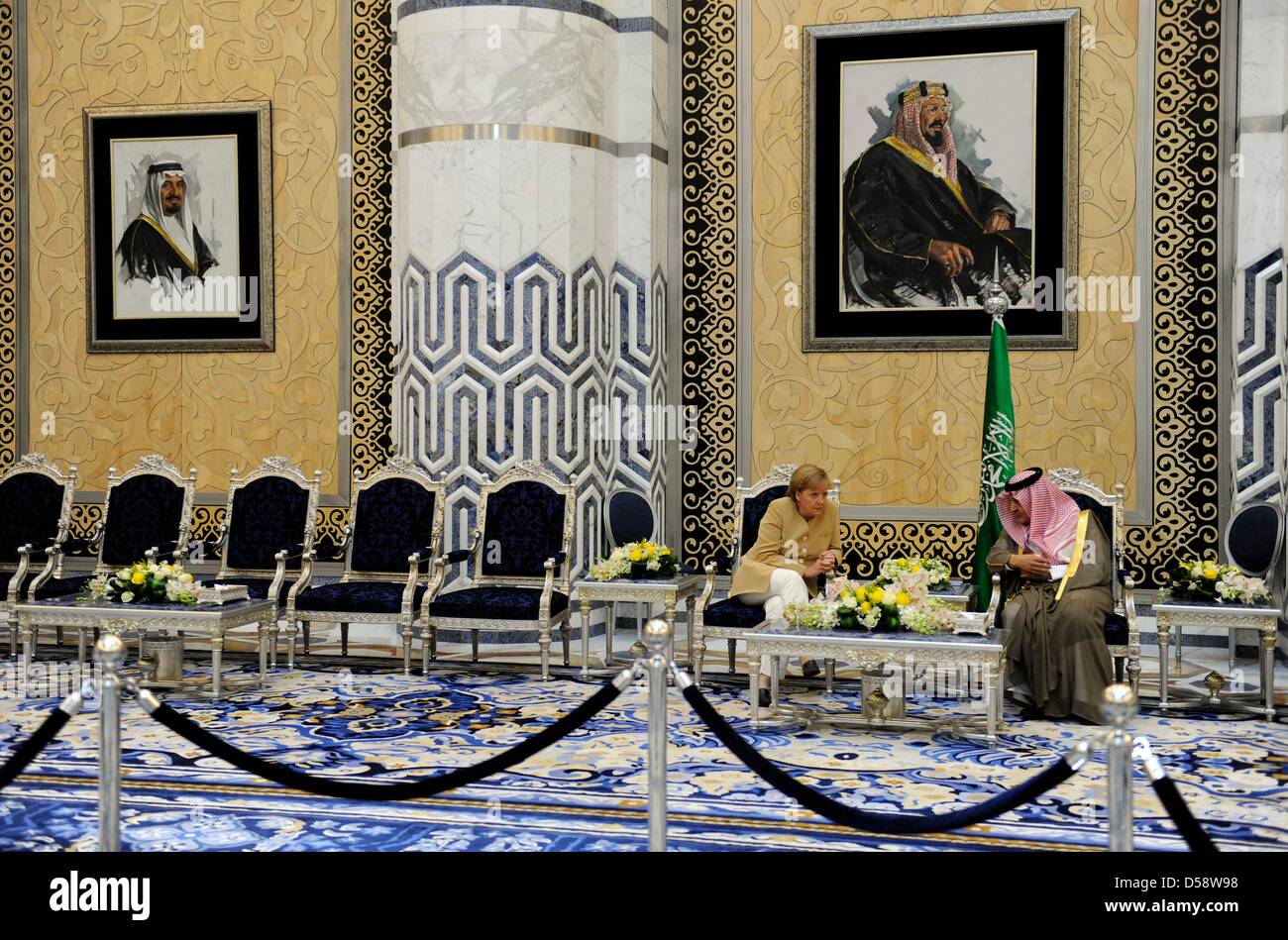 German Chancellor Angela Merkel talks with Saudi Arabia's Foreign Minister Prince Saud Al Faisal bin Abdulaziz Al Saud at airport in Jeddah, Saudi Arabia, 25 May 2010. On the motive in the backround is founder king Abdulaziz Al Saud. Merkel will visit four of six Gulf Cooperation Council countries until 27 May 2010 to improve economic and political ties. Poto: RAINER JENSEN Stock Photo