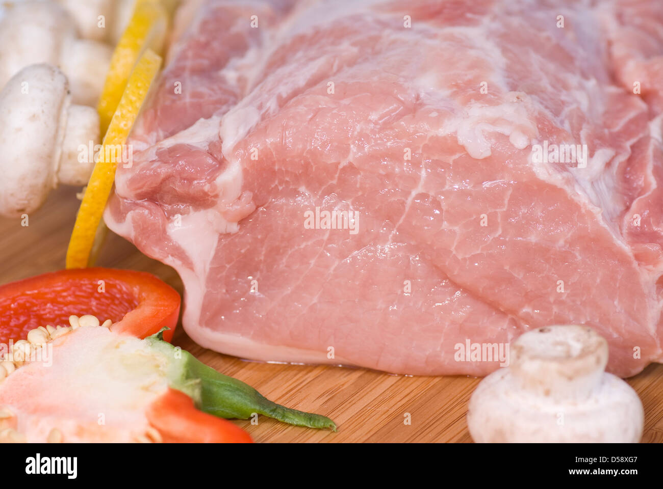 part of pork loin on board with vegetables Stock Photo
