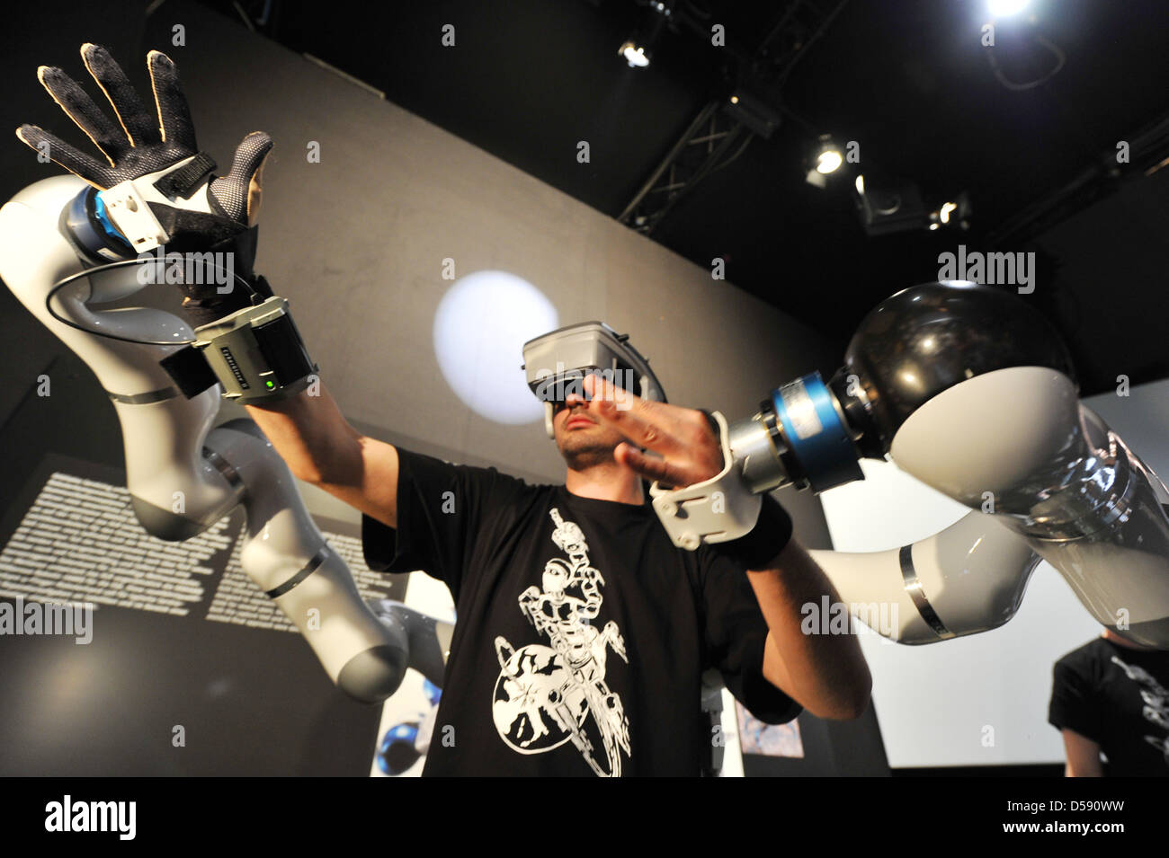 A man steers the humanoid robot 'SpaceJustin' in a simulated space mission at the Space Pavillon of the International Aerospace Exhibition (ILA) in Schoenefeld, Germany, 04 June 2010. From 08 to 13 June 2010, 1150 exhibitors from 48 countries present innovative products and showcase aircrafts in many sizes and categories on ground and in the air. Photo: BERND SETTNIK Stock Photo