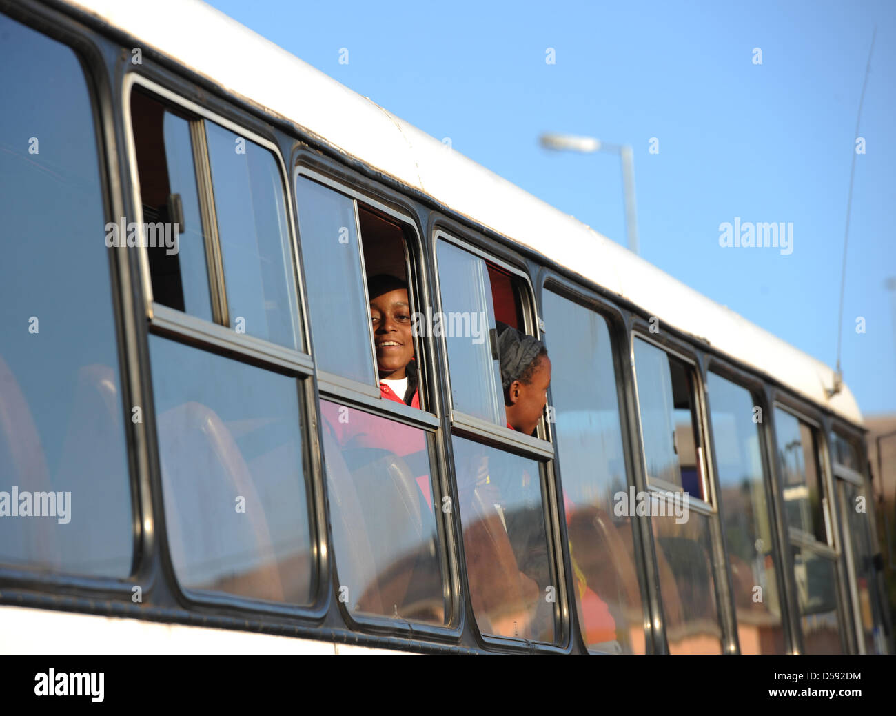 African kids look out of bus windows ahead of a training session of the ...