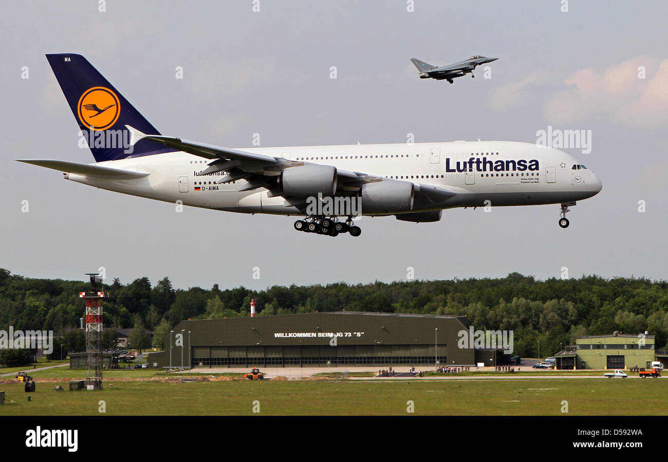 An Airbus A380 of German airline Lufthansa is accompanied by a Eurofighter during a low level flight at the Rostock-Laage airport, Germany, 08 June 2010. The training squadron for the Eurofighter jets is located in Rostock-Laage. The A380 is on the way from the ILA in berlin to Frankfurt Main. Photo: BERND WUESTNECK Stock Photo