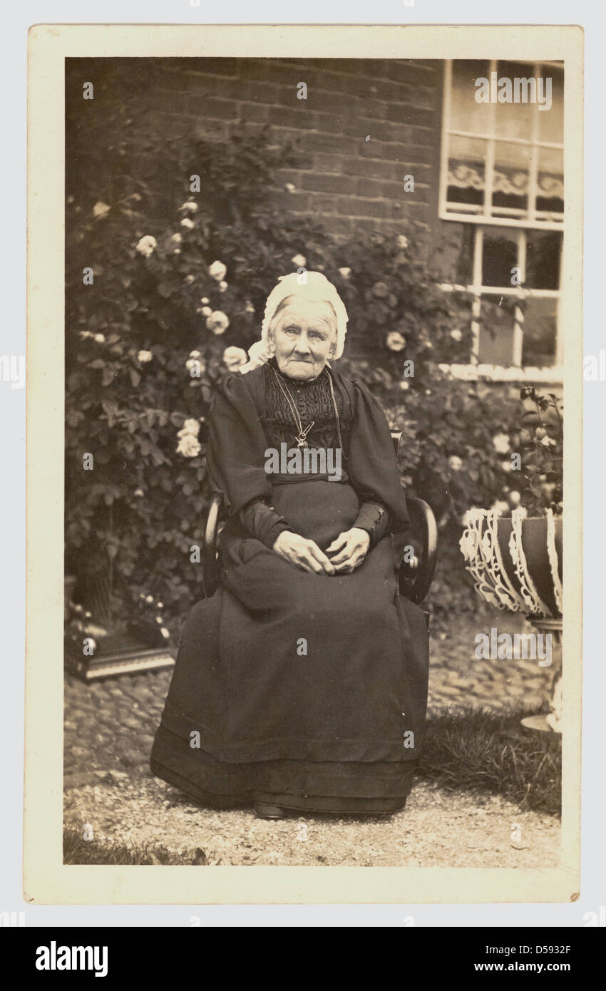 old lady in black dress Elderly woman smartly dressed in a black dress and holding a glass of sparkling wine Stock Photo