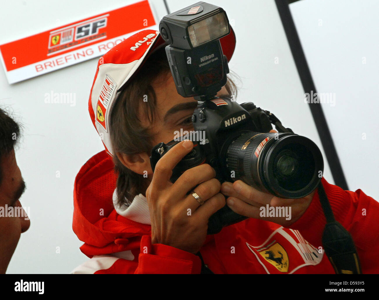 Spanish driver Fernando Alonso of Scuderia Ferrari checks out the camera of an Italian photographer in the paddock of Gille Villeneuve race track in Montreal, Canada, 10 June 2010. The Formula 1 Grand Prix of Canada will be held on 13 June. Photo: JENS BUETTNER Stock Photo