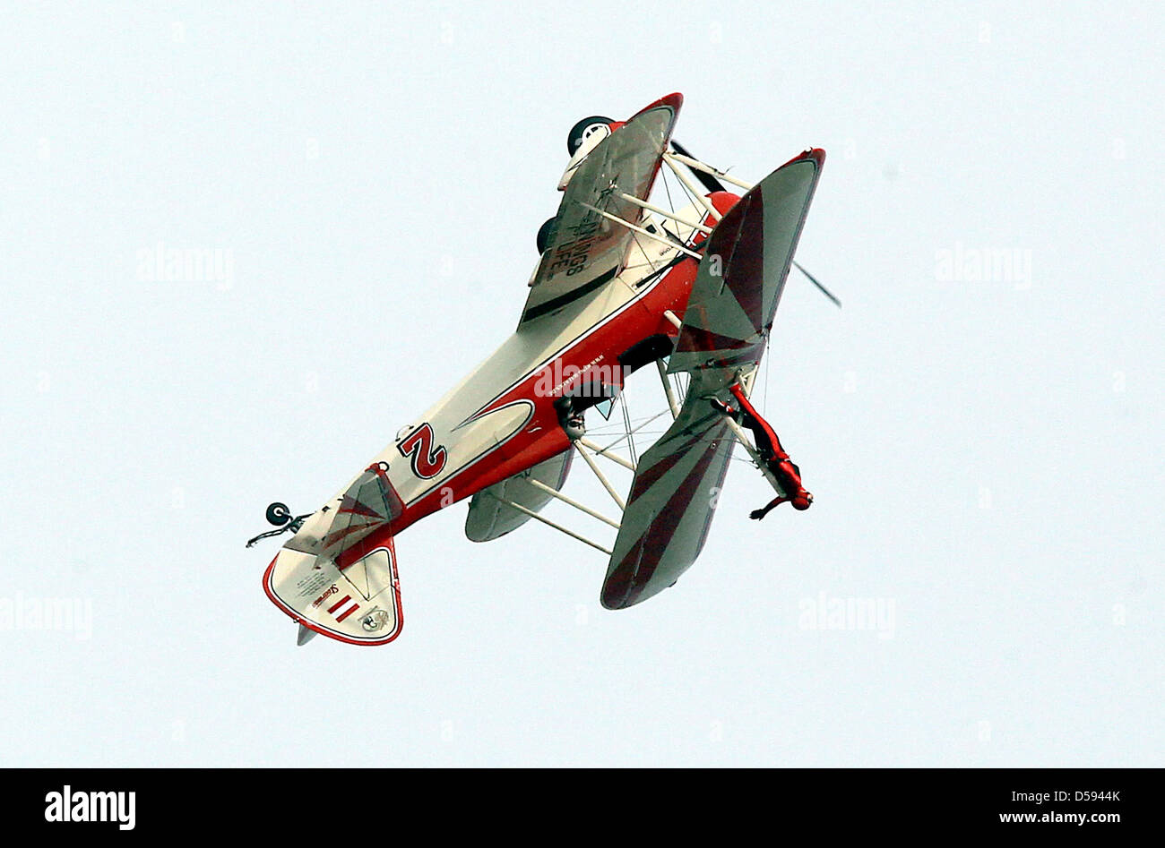 'Lady King Walker' Peggy Krainz performs acrobatics on the deck of a Boeing Stearman PT 17 during the International Aerospace Show ILA 2010 in Schoenefeld Germany, 11 June 2010. A total of 1,153 exhibitors from 47 nations present some 300 airplanes, products and product ideas from 08 June to 13 June 2010. Photo: WOLFGANG KUMM Stock Photo