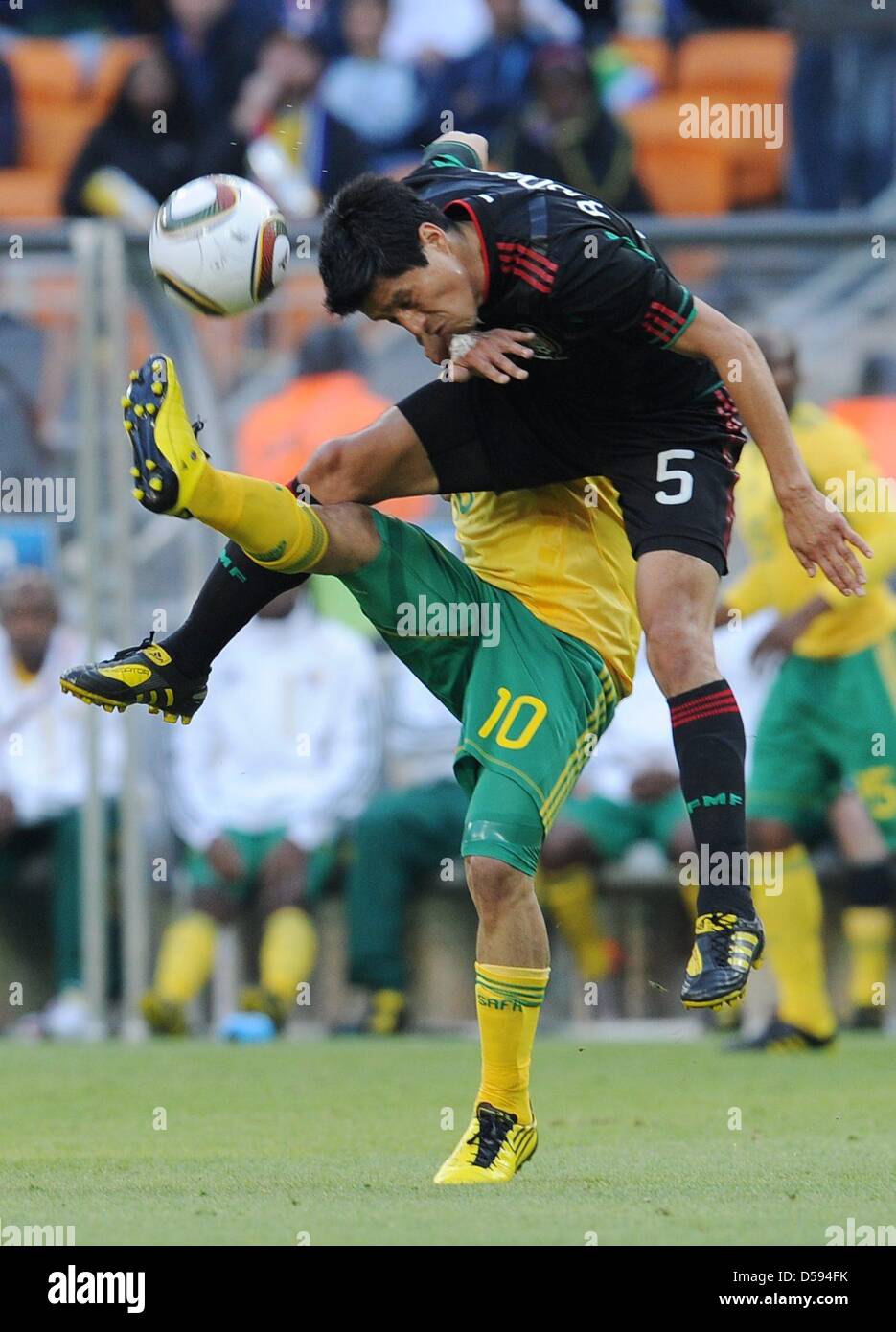 Steven Pienaar (back) of South Africa vies with Ricardo Osorio (front) of Mexico during the 2010 FIFA World Cup opening match at Soccer City stadium in Johannesburg, South Africa 11 June 2010. Photo: Achim Scheidemann dpa Please refer to http://dpaq.de/FIFA-WM2010-TC  +++(c) dpa - Bildfunk+++ Stock Photo