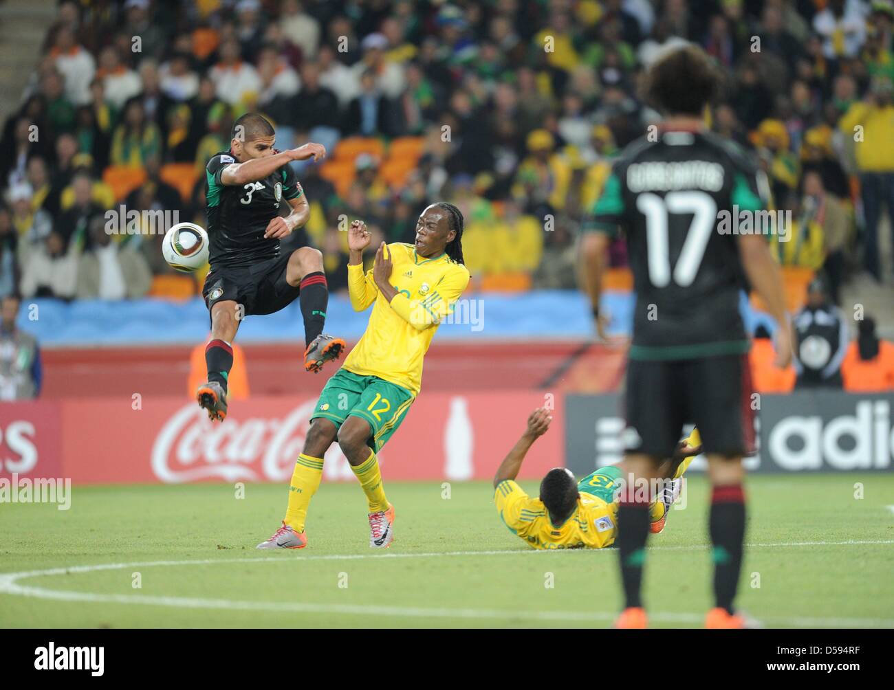 South Africa's Reneilwe Letsholonyane (C) vies with Mexico's Carlos Salcido during the opening match between South Africa and Mexico at the 2010 FIFA World Cup at Soccer City stadium in Johannesburg, South Africa 11 June 2010. Photo: Achim Scheidemann dpa - Please refer to http://dpaq.de/FIFA-WM2010-TC  +++(c) dpa - Bildfunk+++ Stock Photo