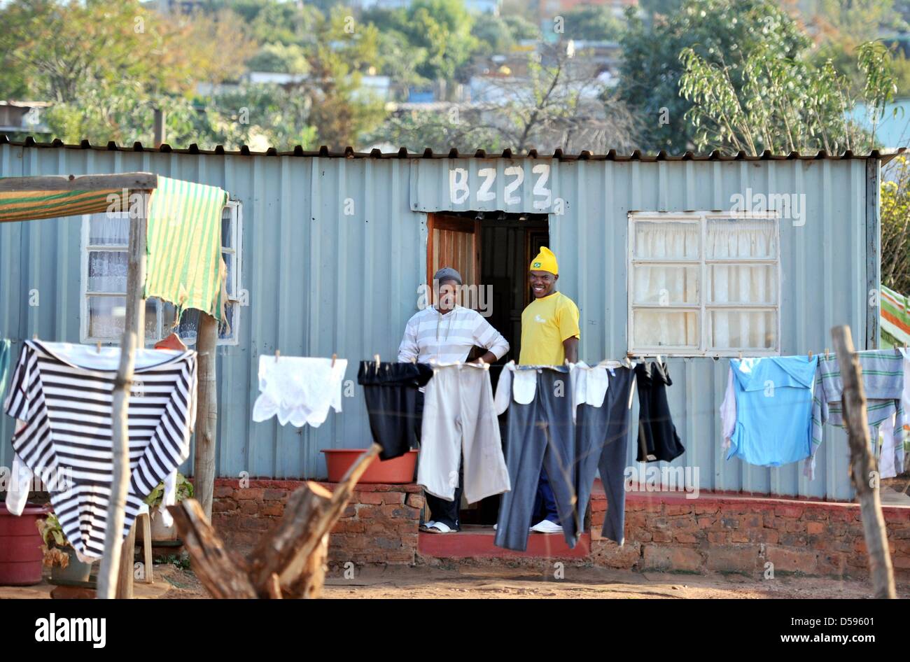 People stand in front of a house in a township in Atteridgeville near