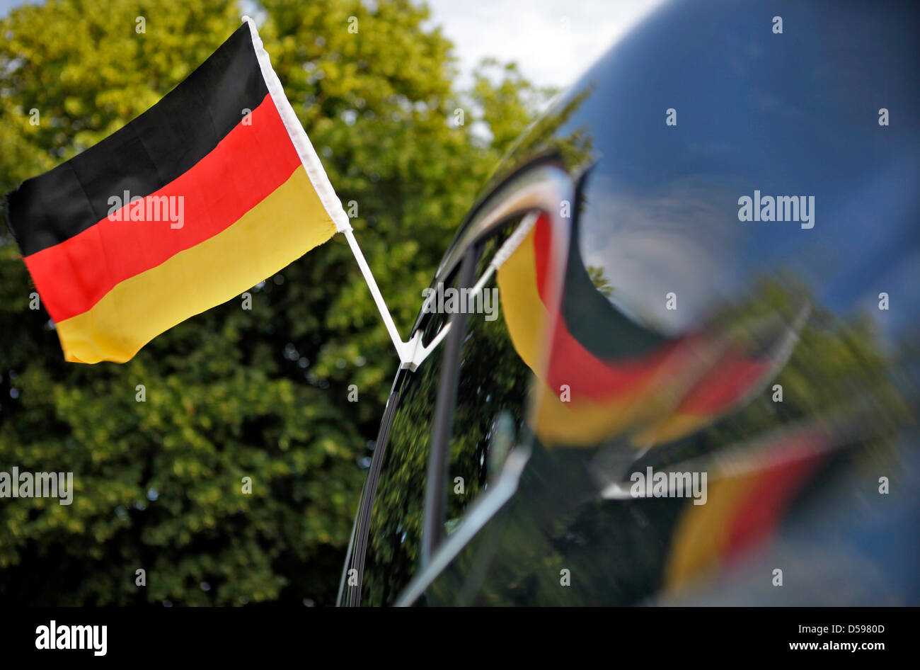 Deutschland-Flagge und deutsche Flagge auf einem Außenspiegel an einem Auto  gegen blauen Himmel, Ringsheim, Baden-Württemberg Stockfotografie - Alamy