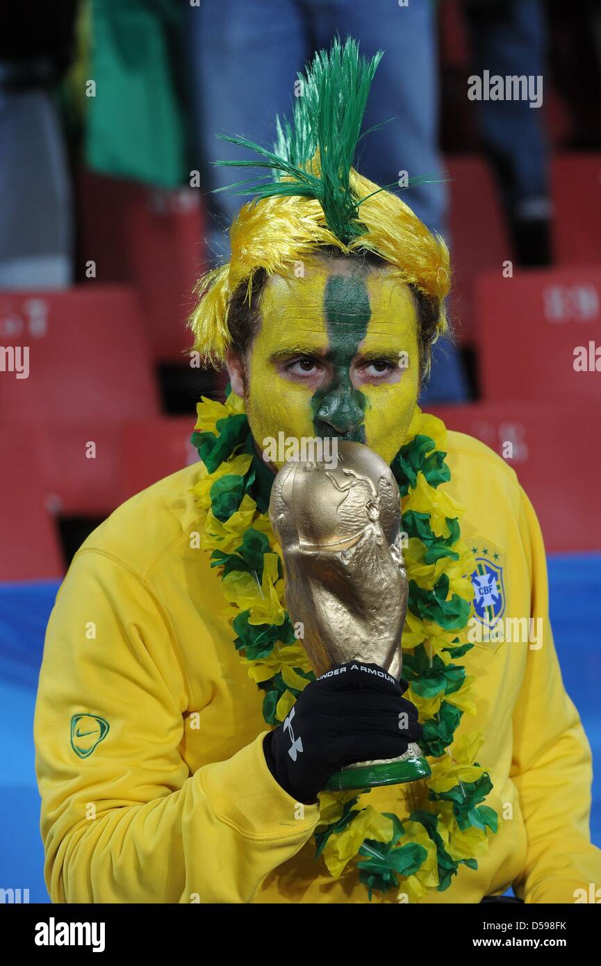 A Brazilian fan kisses a mock-up world cup trophy prior to the 2010 FIFA World Cup group G match between Brazil and North Korea at Ellis Park stadium in Johannesburg, South Africa 15 June 2010. Photo: Achim Scheidemann - Please refer to http://dpaq.de/FIFA-WM2010-TC  +++(c) dpa - Bildfunk+++ Stock Photo