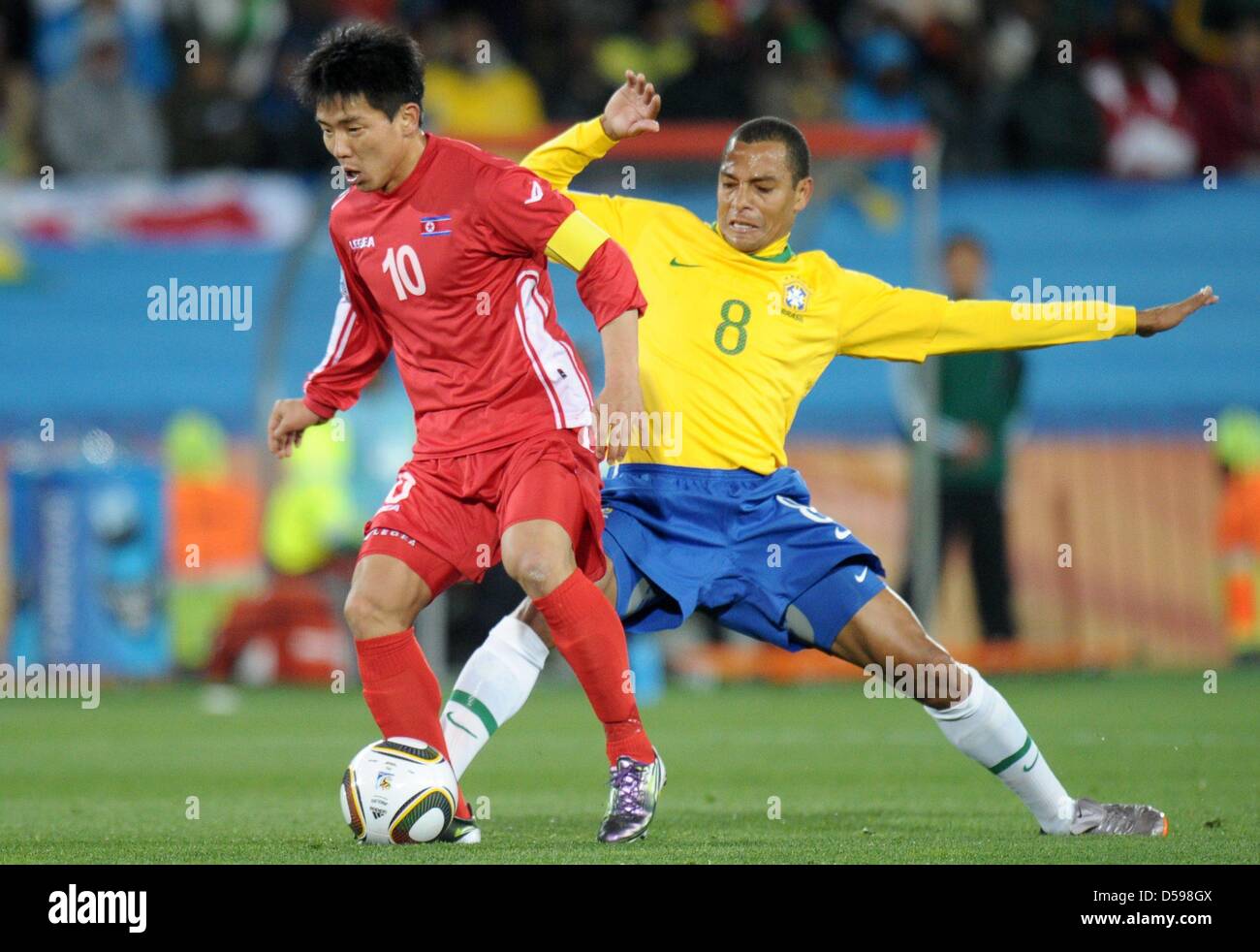 Gilberto Silva (R) of Brazil vies with Hong Yong Jo of North Korea during the FIFA World Cup 2010 group G match between Brazil and North Korea at Ellis Park Stadium in Johannesburg, South Africa 15 June 2010. Photo: Ronald Wittek dpa - Please refer to http://dpaq.de/FIFA-WM2010-TC  +++(c) dpa - Bildfunk+++ Stock Photo