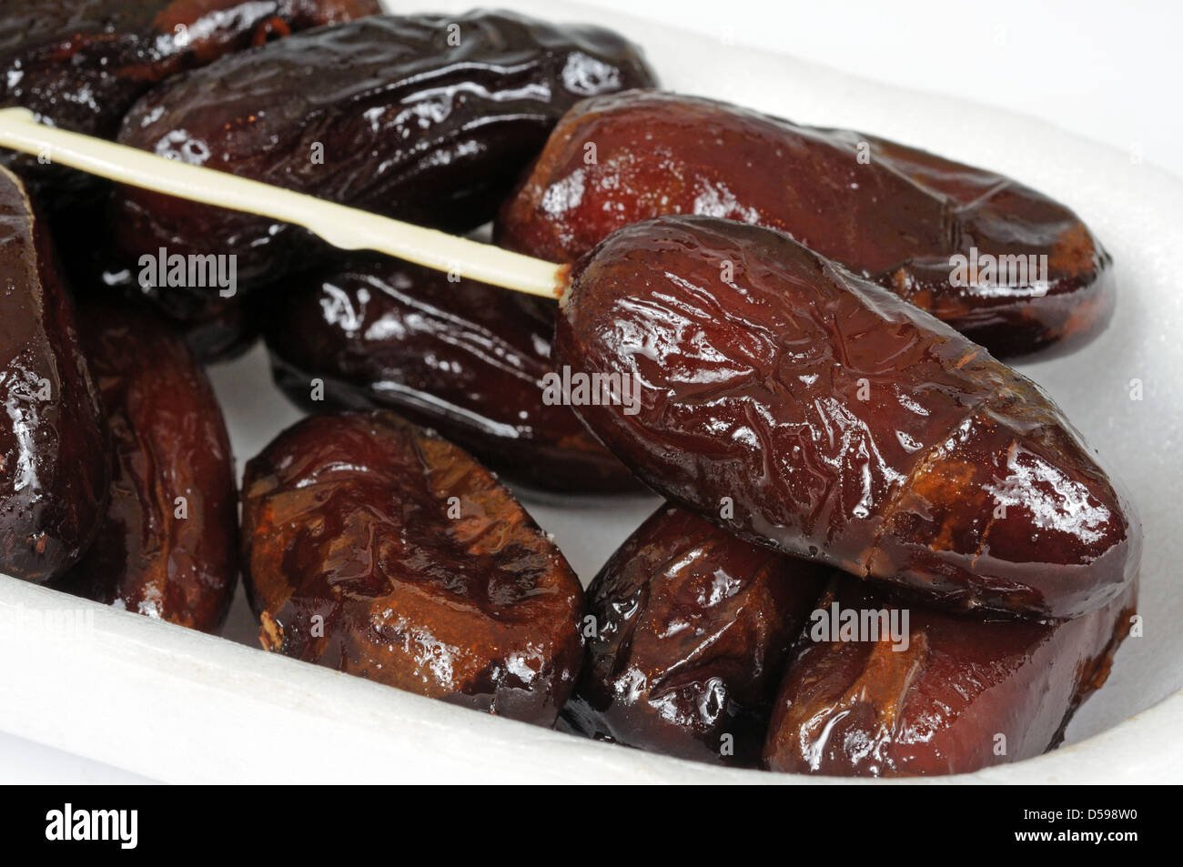 Sticky dates in a white box with a plastic skewer Stock Photo Alamy
