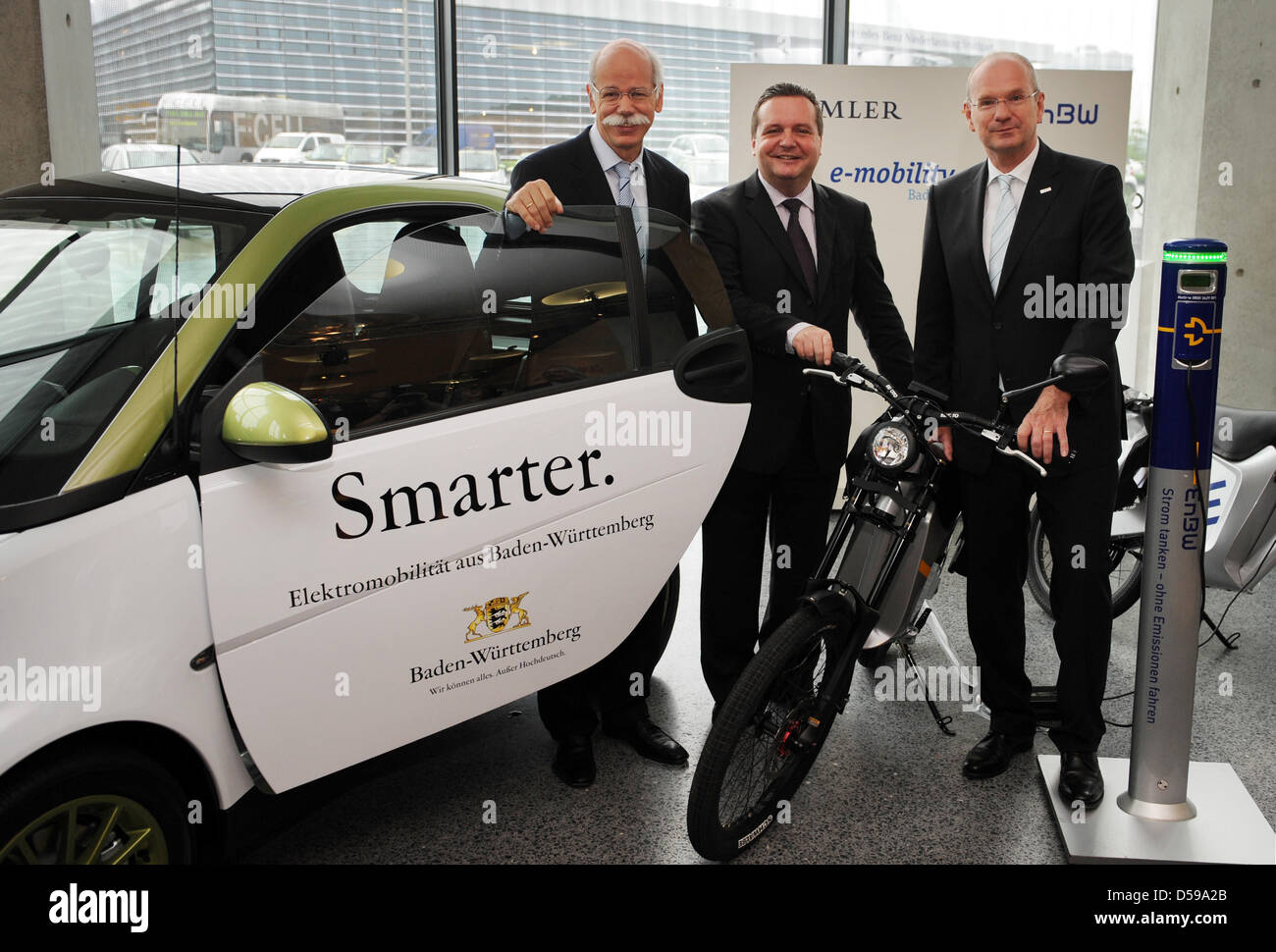 Dieter Zetsche (L-R), CEO of Daimler AG, Stefan Mappus, Prime Minister of Baden-Wuerttemberg, and Hans-Peter Villis, CEO of EnBW, stand next to a smart electric drive and an electric scooter in Stuttgart, Germany, 18 June 2010. Car manufacturer Daimler, power supplier EnBW and Baden-Wuerttemberg want to build about 700 loading stations until the end of 2011 and test 200 vehicles wi Stock Photo