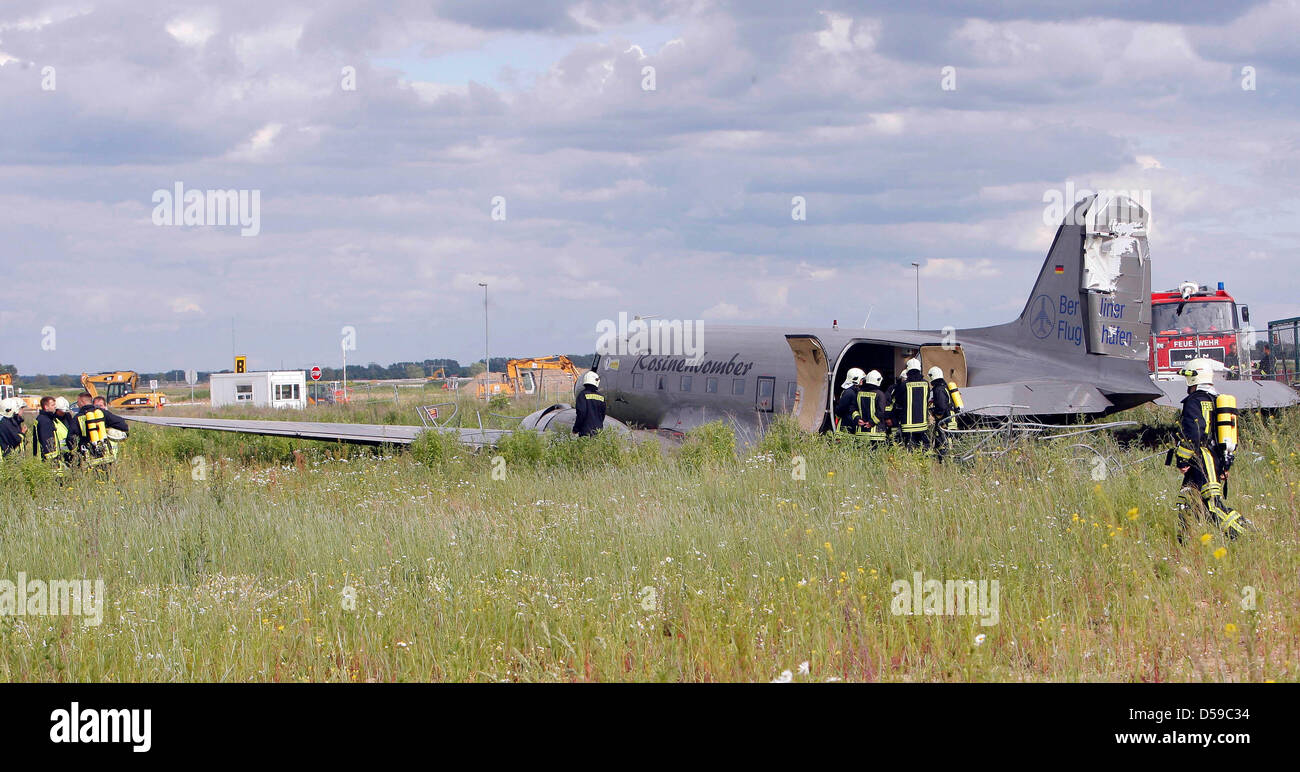 Fire fighters examine a crashed Raisin Bomber, aka Candy Bomber on a field near Schoenefeld, Germany, 19 June 2010. Four of the 25 passengers were injured in the emergency landing. The historic airplane crashed for yet uncertain reasons after the take-off. Photo: NESTOR BACHMANN Stock Photo