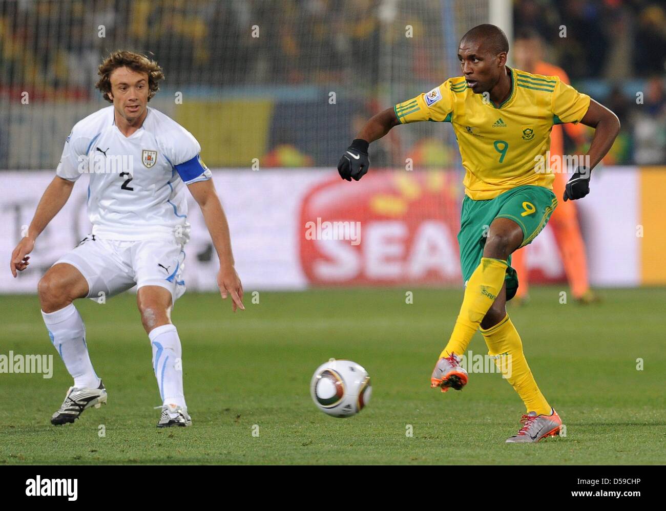 Uruguay's Diego Lugano (L) in action against South Africa's Katlego Mphela during the 2010 FIFA World Cup group A match between South Africa and Uruguay at Loftus Versfeld Stadium in Pretoria, South Africa 16 June 2010. Photo: Achim Scheidemann - Please refer to http://dpaq.de/FIFA-WM2010-TC Stock Photo