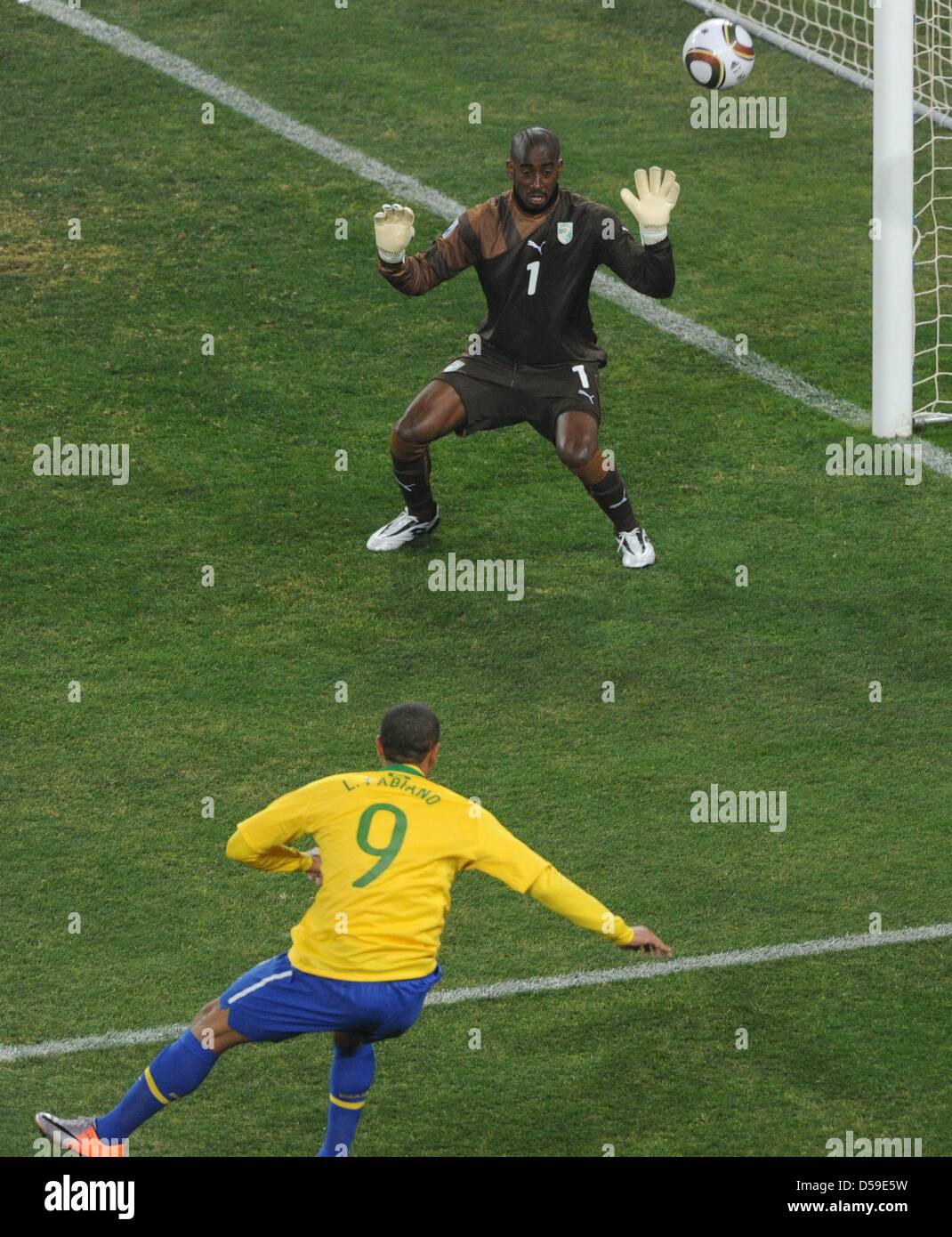 Brazil's Luis Fabiano scores the 1-0 against Ivory Coast's goalkeeper Boubacar Barry during the 2010 FIFA World Cup group G match between Brazil and Ivory Coast at Soccer City Stadium in Johannesburg, South Africa 20 June 2010. Photo: Marcus Brandt dpa - Please refer to http://dpaq.de/FIFA-WM2010-TC  +++(c) dpa - Bildfunk+++ Stock Photo