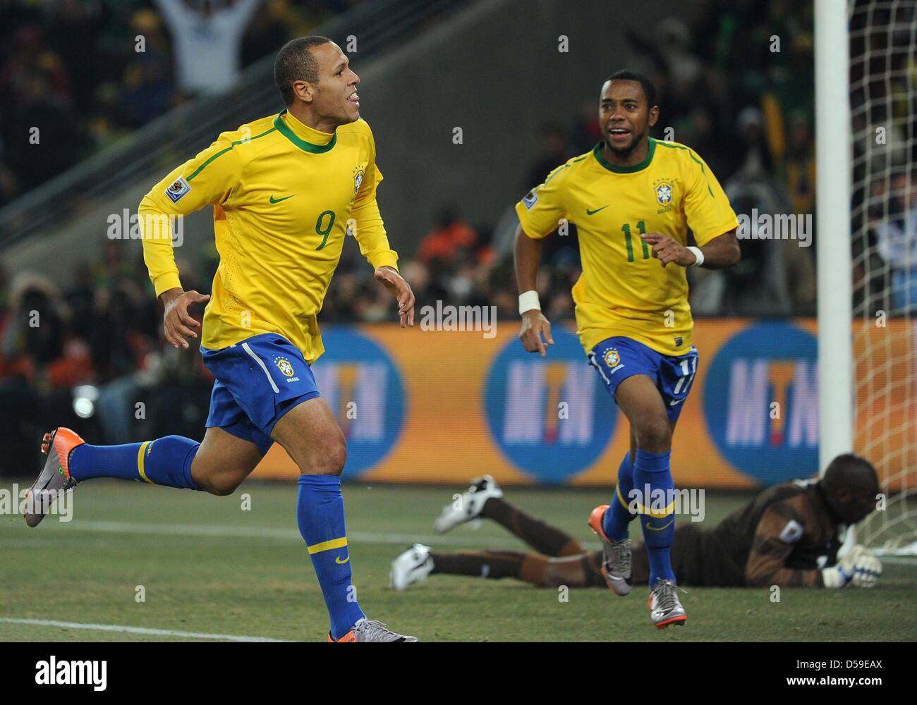 Brazil's Luis Fabiano (L) celebrates scoring with team mate Robinho as Ivory Coast's goalkeeper Boubacar Barry lies beaten on the ground during the 2010 FIFA World Cup group G match between Brazil and Ivory Coast at Soccer City Stadium in Johannesburg, South Africa 20 June 2010. Photo: Achim Scheidemann dpa - Please refer to http://dpaq.de/FIFA-WM2010-TC Stock Photo