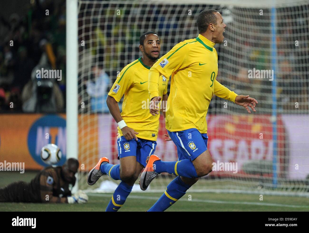Brazil's Luis Fabiano (R) celebrates scoring with team mate Robinho as Ivory Coast's goalkeeper Boubacar Barry lies beaten on the ground during the 2010 FIFA World Cup group G match between Brazil and Ivory Coast at Soccer City Stadium in Johannesburg, South Africa 20 June 2010. Photo: Achim Scheidemann dpa - Please refer to http://dpaq.de/FIFA-WM2010-TC Stock Photo