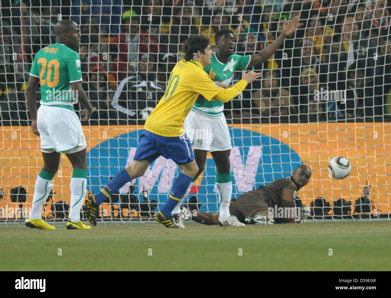 Goalkeeper Boubacar Barry (R) of Ivory Coast is unable to save a shot of Luis Fabiano (not pictured) while Kaka (2-L) celebrates during the FIFA World Cup 2010 group G match between Brazil and Ivory Coast at the Soccer City Stadium in Johannesburg, South Africa 20 June 2010. Photo: Ronald Wittek dpa - Please refer to http://dpaq.de/FIFA-WM2010-TC Stock Photo