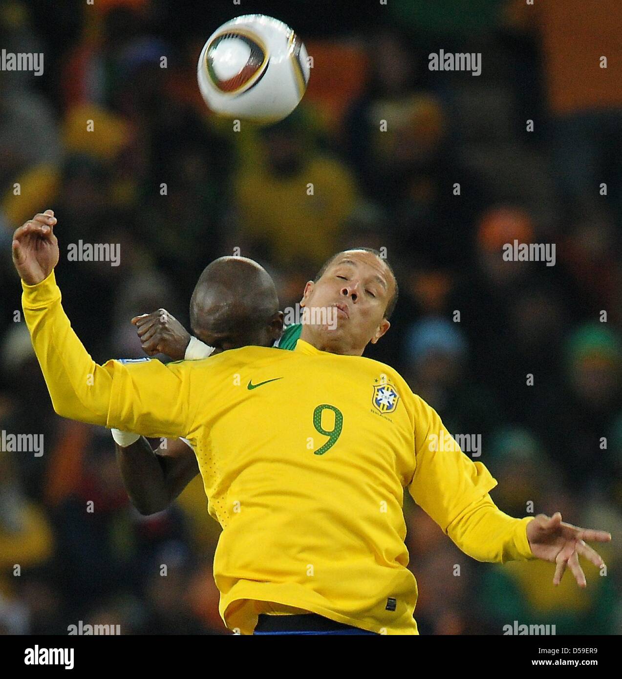 Luis Fabiano (front) of Brazil vies with Didier Zokora of Ivory Coast during the FIFA World Cup 2010 group G match between Brazil and Ivory Coast at the Soccer City Stadium in Johannesburg, South Africa 20 June 2010. Photo: Ronald Wittek dpa - Please refer to http://dpaq.de/FIFA-WM2010-TC Stock Photo
