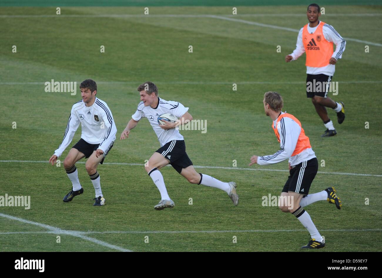 Germany's Thomas Mueller (L-R), Toni Kroos, Per Mertesacker and Dennis Aogo play rugby during a training session of the German national soccer team at the Super Stadium in Atteridgeville near Pretoria, South Africa, 21 June 2010. Photo: Marcus Brandt dpa -  +++(c) dpa - Bildfunk+++ Stock Photo