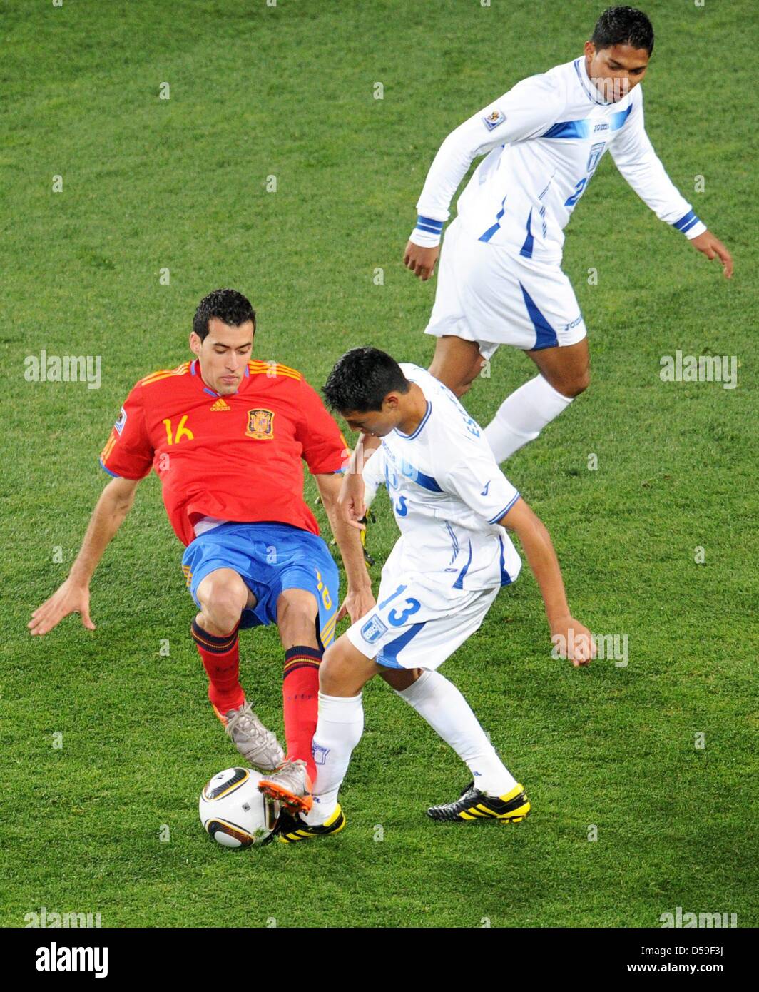 Sergio Busquets (L) of Spain vies with Roger Espinoza (C) and Emilio Izaguirre (R) of Honduras during the FIFA World Cup 2010 group H match between Spain and Honduras at the Ellis Park Stadium in Johannesburg, South Africa 21 June 2010. Photo: Bernd Weissbrod dpa - Please refer to http://dpaq.de/FIFA-WM2010-TC  +++(c) dpa - Bildfunk+++ Stock Photo