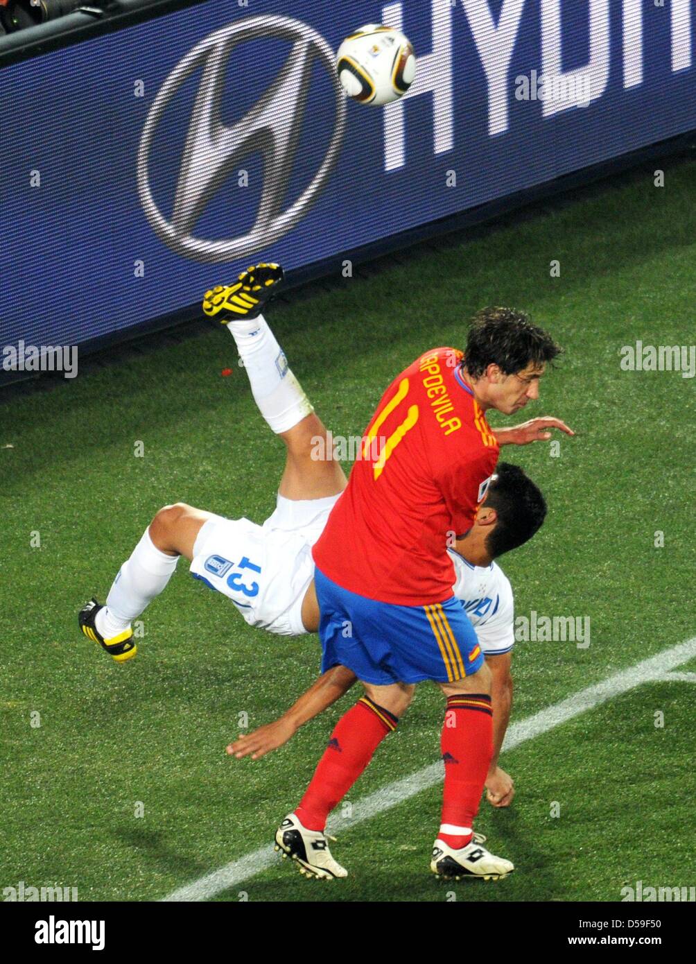Roger Espinoza (back) of Honduras vies with Joan Capdevila of Spain during the FIFA World Cup 2010 group H match between Spain and Honduras at the Ellis Park Stadium in Johannesburg, South Africa 21 June 2010. Photo: Bernd Weissbrod dpa - Please refer to http://dpaq.de/FIFA-WM2010-TC  +++(c) dpa - Bildfunk+++ Stock Photo