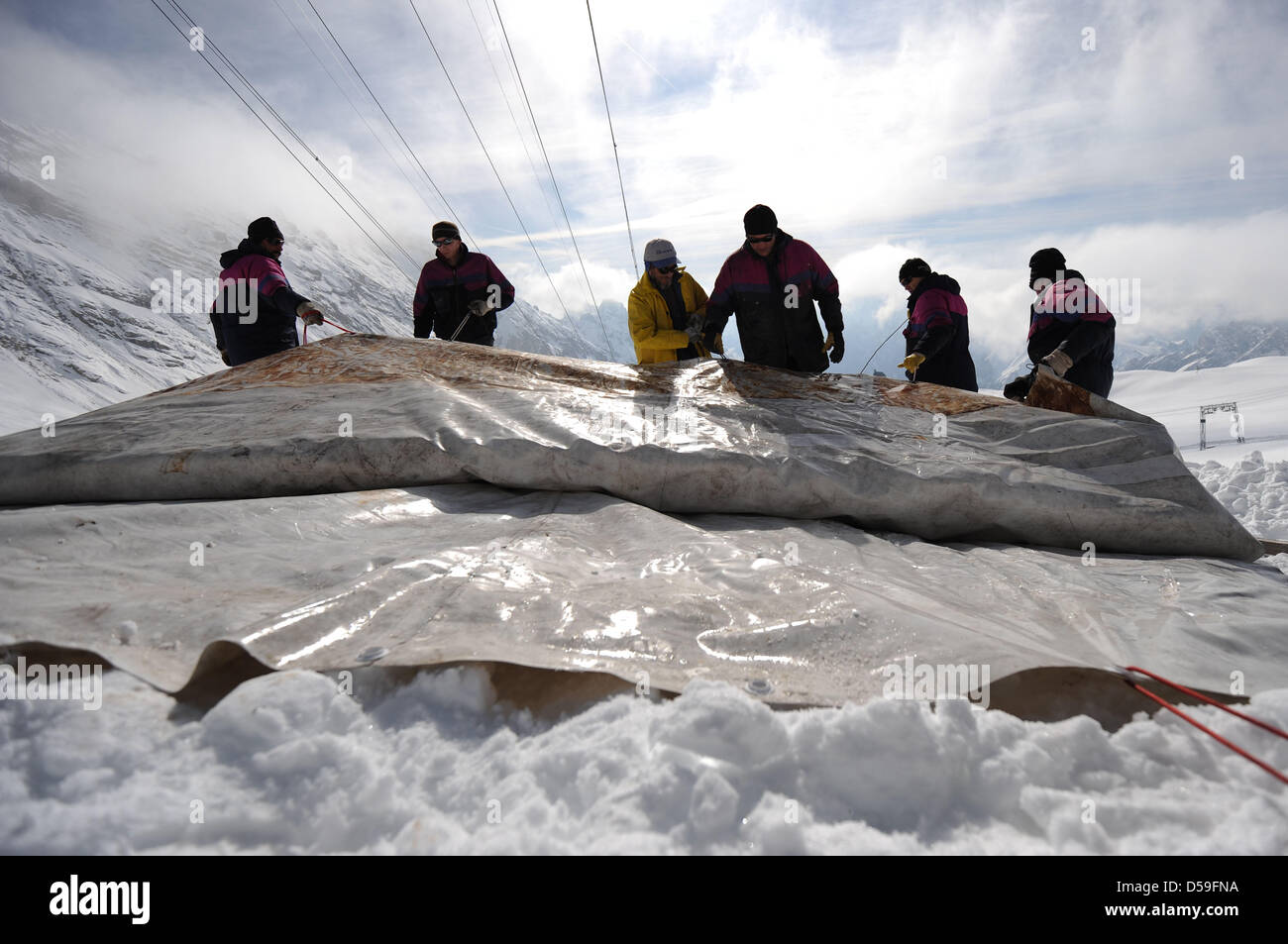 On the Zugspitze, the glacier is being covered by workers in Garmisch-Partenkirchen (Upper Bavaria), Germany, 23 June 2010. In order to protect the glacier on top of the 2,962-meter-high Zugspitze from sun and rain, it is being wrapped up. Photo: Andreas Gebert Stock Photo