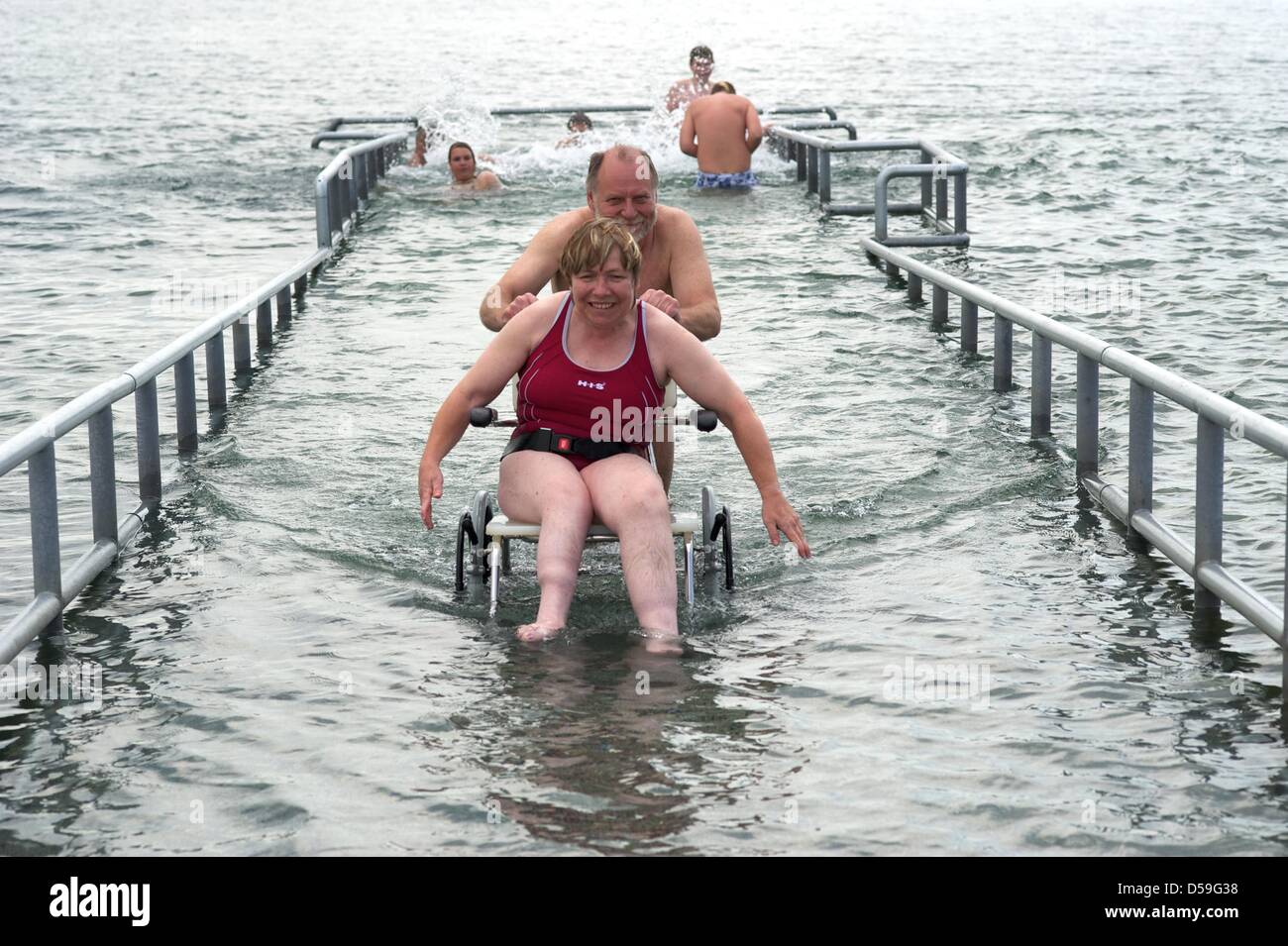 The wheelchair user Martina Scholz tries out the new disability accessible bathing jetty at the Cospuden lake in Leizig, together with her helper Rolf Sonderhaus of the association for disabled people in Leipzig, Germany, 23 June 2010. According to the association, this lake- situated in the south of Leipzig- offers the first handicapped accessible bathing jetty in the whole of Eur Stock Photo