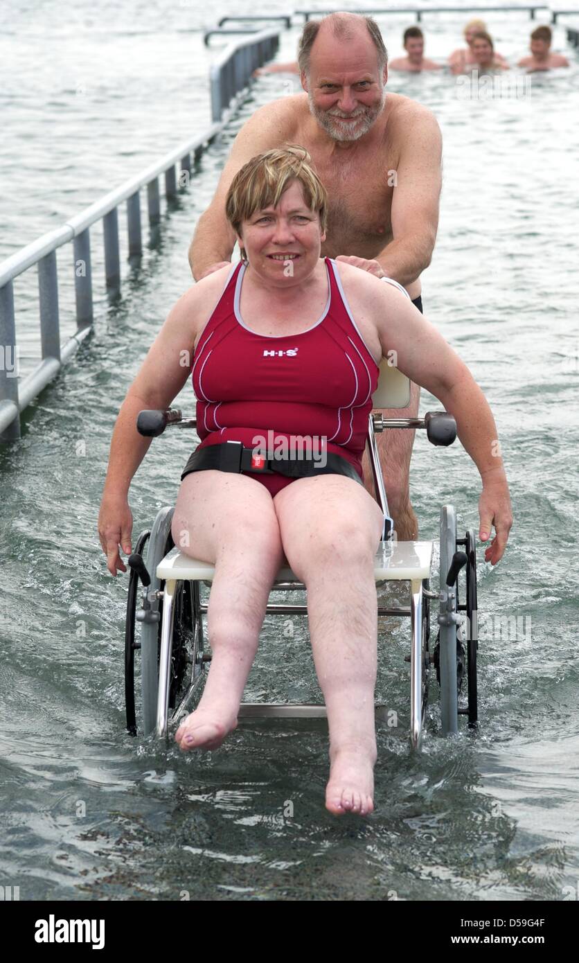 The wheelchair user Martina Scholz tries out the new disability accessible bathing jetty at the Cospuden lake in Leizig, together with her helper Rolf Sonderhaus of the association for disabled people in Leipzig, Germany, 23 June 2010. According to the association, this lake- situated in the south of Leipzig- offers the first handicapped accessible bathing jetty in the whole of Eur Stock Photo