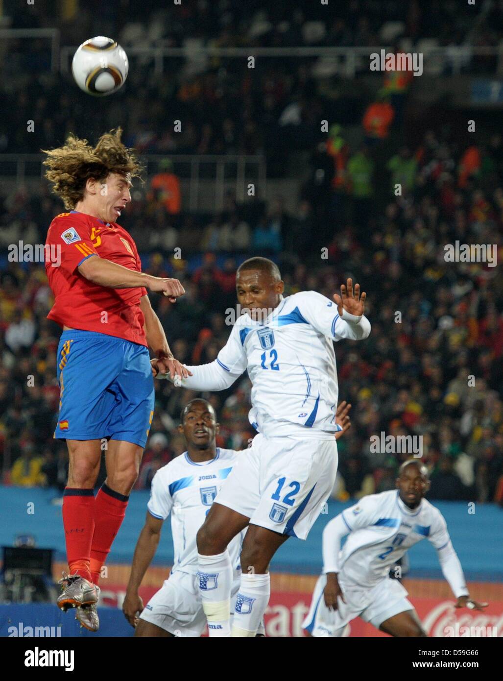 Carles Puyol (L) of Spain vies with Georgie Welcome (C) of Honduras during the FIFA World Cup 2010 group H match between Spain and Honduras at the Ellis Park Stadium in Johannesburg, South Africa 21 June 2010. Photo: Ronald Wittek dpa - Please refer to http://dpaq.de/FIFA-WM2010-TC Stock Photo