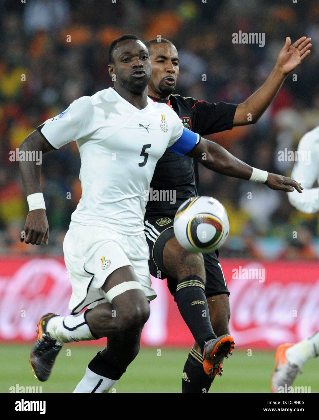 John Mensah (R) of Ghana vies with Cacau of Germany during the FIFA World Cup 2010 group D match between Ghana and Germany at the Soccer City Stadium in Johannesburg, South Africa 23 June 2010. Photo: Bernd Weissbrod dpa - Please refer to http://dpaq.de/FIFA-WM2010-TC Stock Photo
