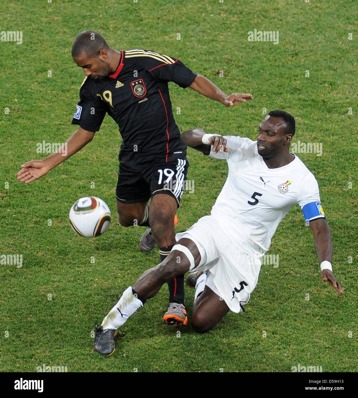 Germany's Cacau (L) and Ghana's John Mensah vie for the ball during the 2010 FIFA World Cup group D match between Ghana and Germany at Soccer City, Johannesburg, South Africa 23 June 2010. Photo: Achim Scheidemann - Please refer to http://dpaq.de/FIFA-WM2010-TC Stock Photo