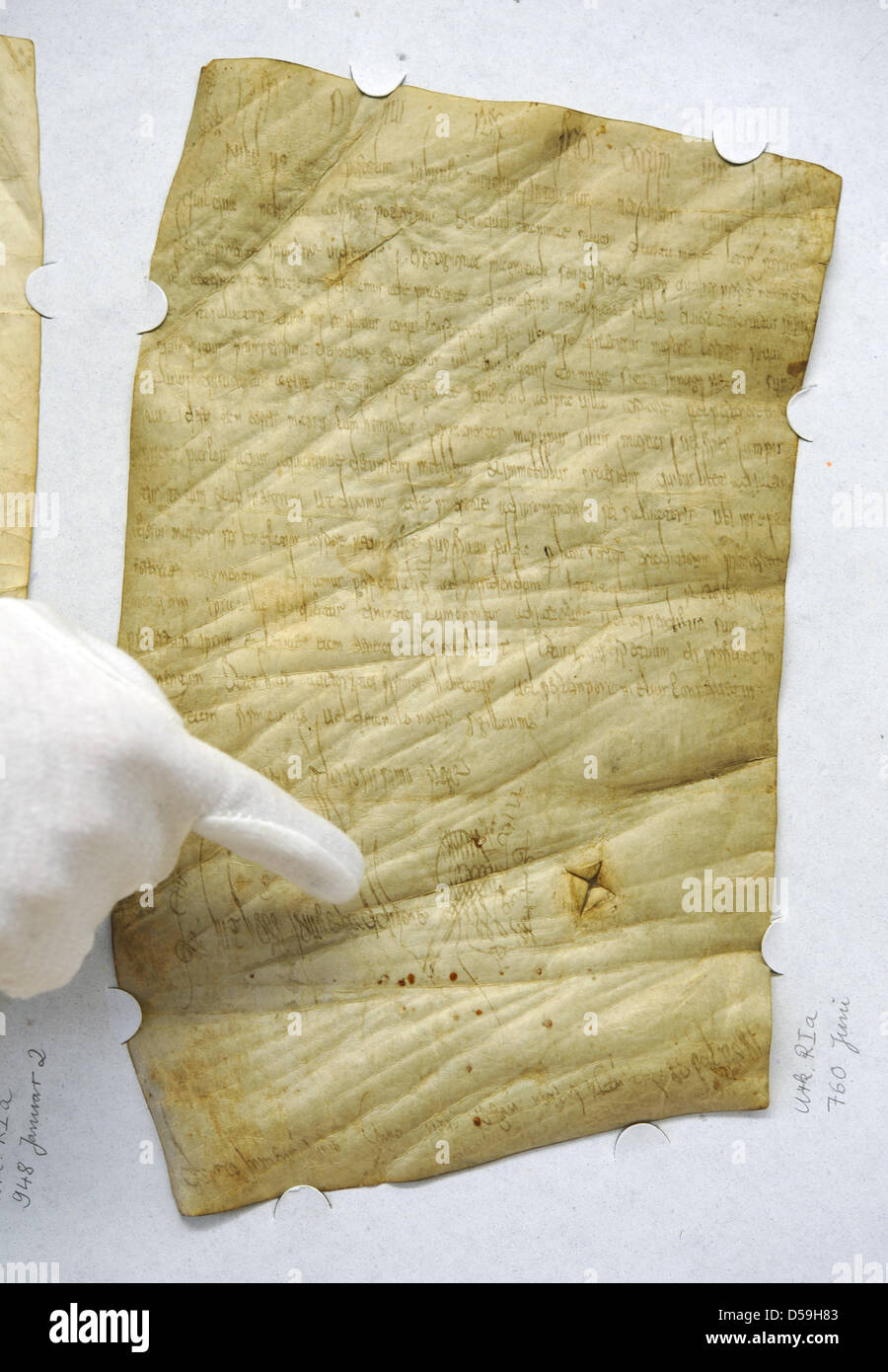 A hand points on the eldest preserved document issued by a knig in Marburg, Germany, 23 June 2010. The pergament was issued in 1250 AD by Carolingian King Pippn III, father of Charlemagne. In the document, Pippin III donates a large amount to the cloister of Fulda. Photo: Uwe Zucchi Stock Photo