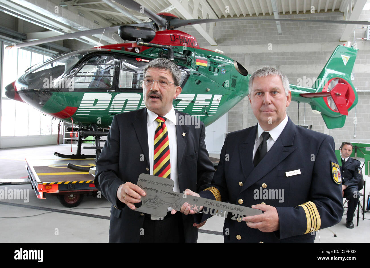 Federal state Mecklenburg-Vorpommern's Minister of Interiors Lorenz Caffier (L) hands the keys for the new headquarters of police helicopter squad to squad leader Hans-Juergen Klingbeil (R) in Rostock-Laage, Germany, 23 June 2010. The squad consists of two Eurocopters and 17 staff members. Photo: bernd Wuestneck Stock Photo