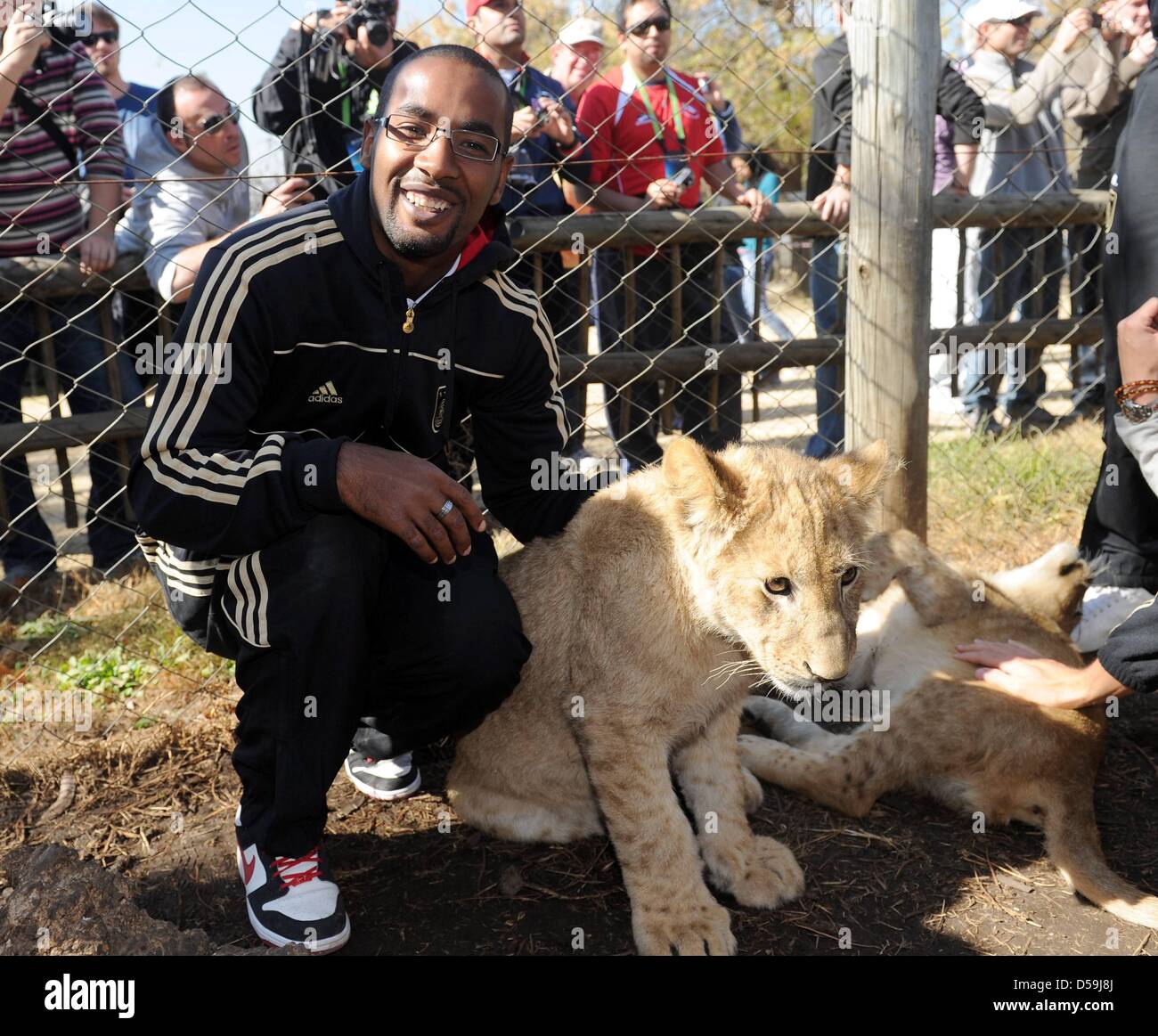 German player Cacau strokes a young lion as the team visits the Lion ...
