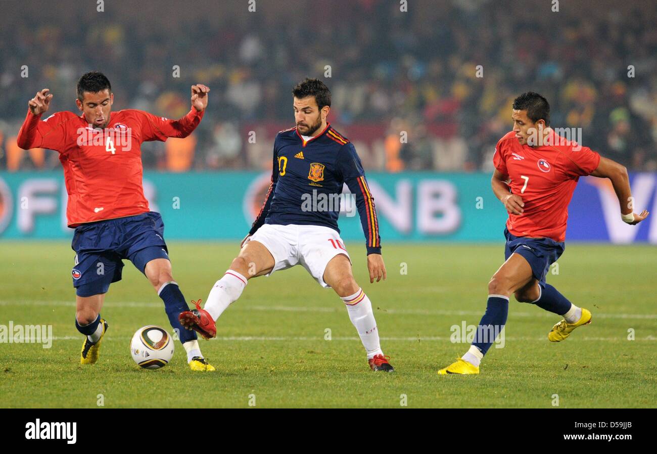 Mauricio Isla (L) and Alexis Sanchez (R) of Chile vie with Cesc Fabregas of Spain during the FIFA World Cup 2010 group H match between Chile and Spain at the Loftus Versfeld Stadium in Pretoria, South Africa 25 June 2010. Photo: Bernd Weissbrod dpa - Please refer to http://dpaq.de/FIFA-WM2010-TC Stock Photo