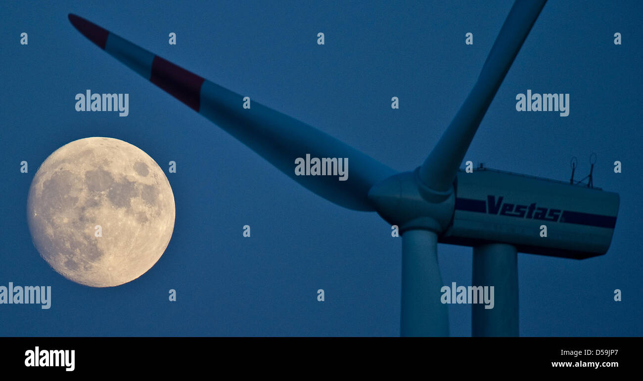 The waxing moon is featured next to a wind turbine in Jacobsdorf, Brandenburg, Germany, 24 June 2010. Full moon will occur 26 June 2010. Moon craters, hills and valleys appear very graphic at the concurrence of light and shade, which can be observed with telescopes or binoculars. The sun beams hit the relief in a shallow manner, which results in long casts of shadows. Photo: Patric Stock Photo