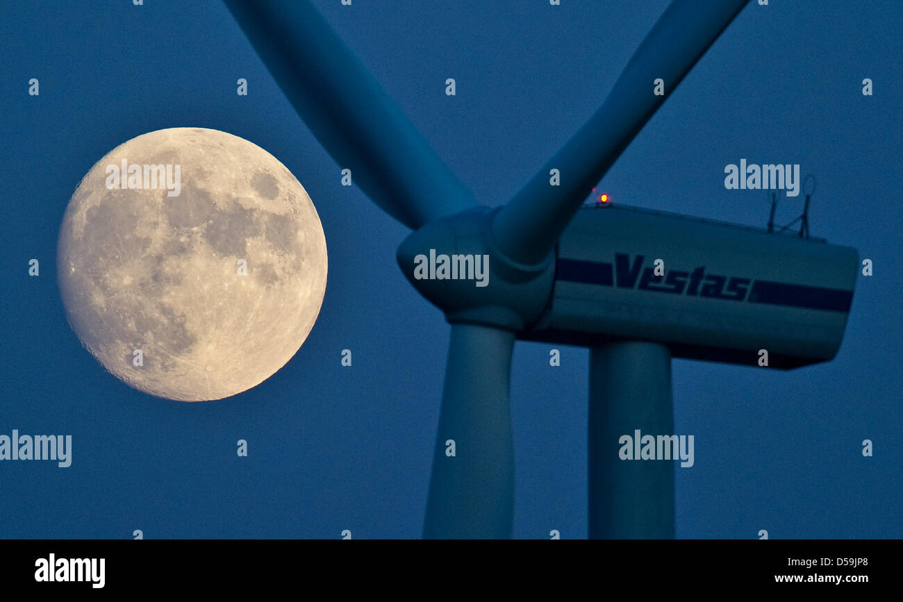 The waxing moon is featured next to a wind turbine in Jacobsdorf, Brandenburg, Germany, 24 June 2010. Full moon will occur 26 June 2010. Moon craters, hills and valleys appear very graphic at the concurrence of light and shade, which can be observed with telescopes or binoculars. The sun beams hit the relief in a shallow manner, which results in long casts of shadows. Photo: Patric Stock Photo