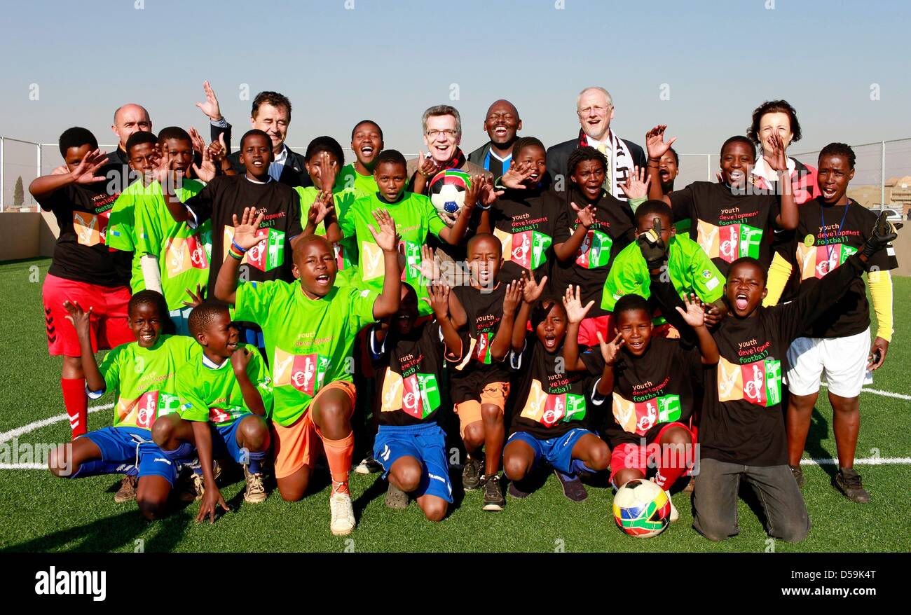 German interior minister Thomas de Maiziere poses with young South African football players during the opening of a football pitch at the Orange Farm township, about 30km south of Johannesburg, South Africa on 27 June 2010. De Maiziere is on a three-day visit to South Africa. Photo: Kerim Okten Stock Photo