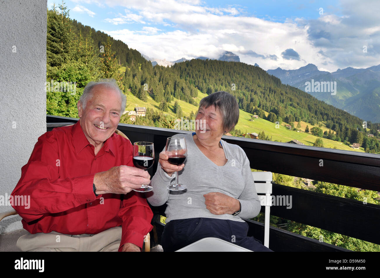 Retired couple enjoy the good life, a glass of wine on holiday in Switzerland. Stock Photo