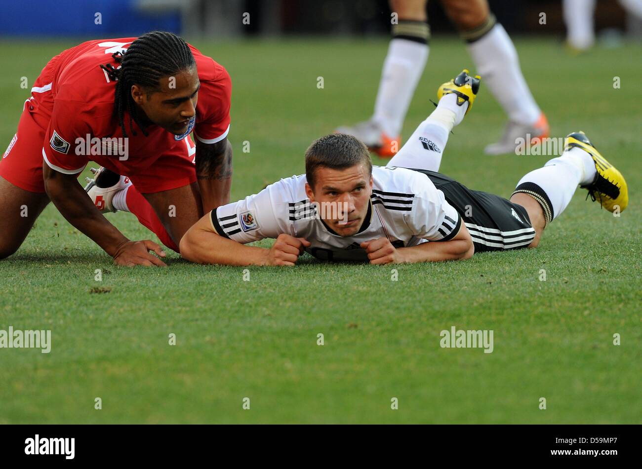 Germany's Lukas Podolski and England's Glen Johnson on the ground during the 2010 FIFA World Cup Round of Sixteen match between Germany and England at the Free State Stadium in Bloemfontein, South Africa 27 June 2010. Photo: Marcus Brandt dpa - Please refer to http://dpaq.de/FIFA-WM2010-TC Stock Photo