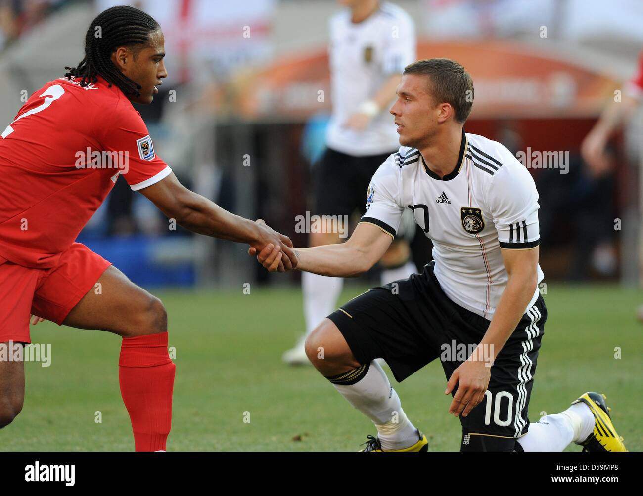 Germany's Lukas Podolski is helped up by England's Glen Johnson during the 2010 FIFA World Cup Round of Sixteen match between Germany and England at the Free State Stadium in Bloemfontein, South Africa 27 June 2010. Photo: Marcus Brandt dpa - Please refer to http://dpaq.de/FIFA-WM2010-TC Stock Photo