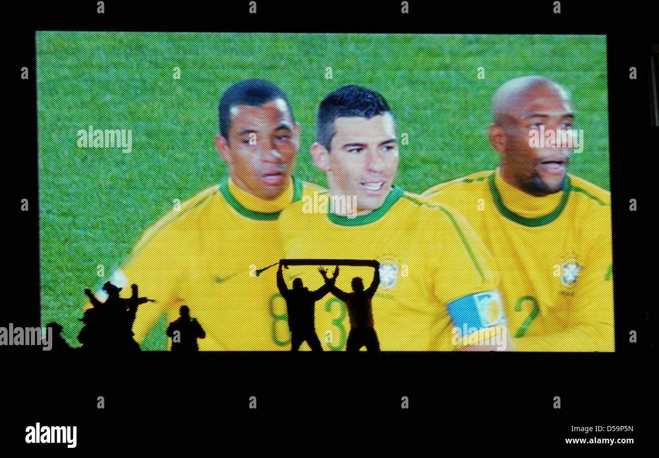 Fans celebrates in front of a big screen showing Brazilian players Gilberto Silva, Lucio and Maicon after the 2010 FIFA World Cup Round of Sixteen match between Brazil and Chile at the Ellis Park Stadium in Johannesburg, South Africa 28 June 2010. Photo: Marcus Brandt dpa - Please refer to http://dpaq.de/FIFA-WM2010-TC  +++(c) dpa - Bildfunk+++ Stock Photo