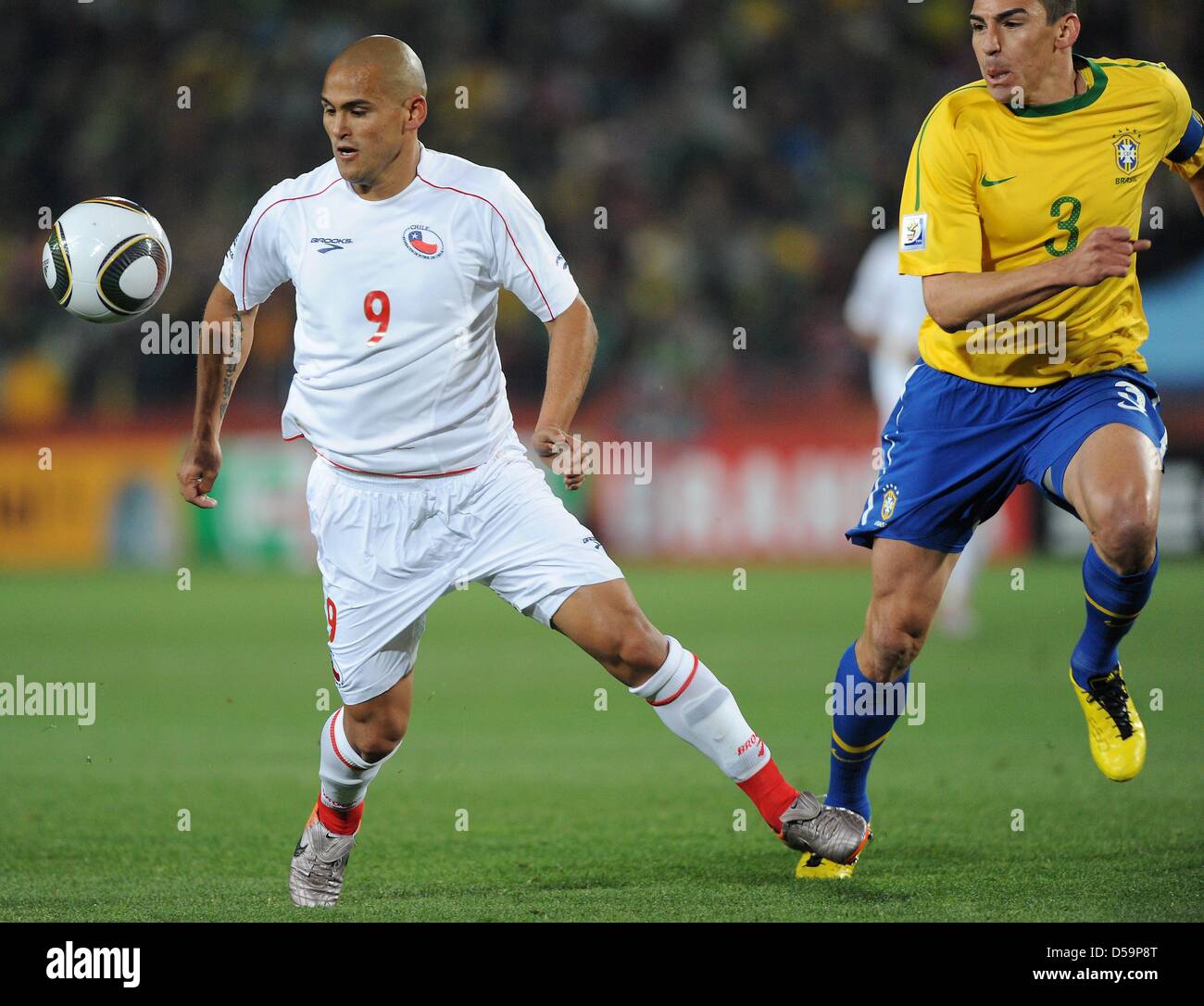Brazil's Lucio (R) vies for the ball with Chile's Humberto Suazo during the 2010 FIFA World Cup Round of Sixteen match between Brazil and Chile at the Ellis Park Stadium in Johannesburg, South Africa 28 June 2010. Photo: Marcus Brandt dpa - Please refer to http://dpaq.de/FIFA-WM2010-TC Stock Photo